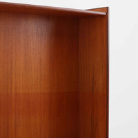 チーク材とオーク材を組み合わせて作られたスウェーデン製のディスプレイシェルフです。幅90cmと使いやすいサイズ感で、上部の棚には本やオブジェを、下部の引き戸と引き出しには日用品を収納できる実用性の高い構成となっています。滑らかな木肌や丁寧な造りには職人技が感じられ、経年により深みを増した木の風合いが空間に温かみをもたらします。リビングやダイニングはもちろん、書斎や寝室の収納兼ディスプレイとしても活躍する、北欧ビンテージ家具らしいシンプルかつ機能的な一台です。