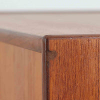 スウェーデン製のチーク材とオーク材を組み合わせたディスプレイシェルフです。幅90cmと程よいサイズ感で、上部の棚は書籍やオブジェの展示に適し、下部の引き戸収納は日用品や小物をすっきりと収めることができます。丸みを帯びた取っ手が温かみのあるアクセントとなり、北欧家具らしいシンプルで実用的なデザインを際立たせています。経年によって深みを増したチークの木目とオークのコントラストが上品な存在感を放ち、リビングや書斎の空間に落ち着いた雰囲気を添えるビンテージ家具です。