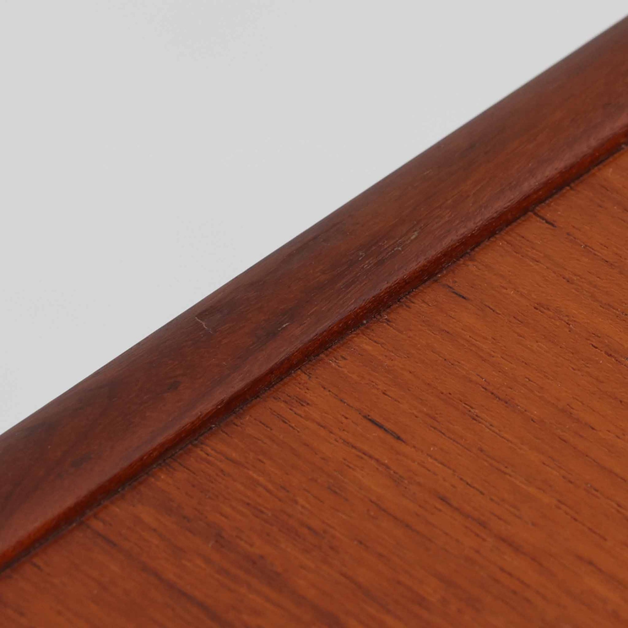 スウェーデン製のディスプレイシェルフです。上段には3段のオープンシェルフが設けられ、本や雑貨、オブジェなどを美しくディスプレイできます。下段にはスライド扉収納が備わり、内部の棚板によって整理しやすく、見せたくない収納にも便利です。チーク材の温もりある木目と、丸い掘り込み取っ手の柔らかなデザインが印象的で、北欧家具らしい穏やかな雰囲気を演出します。背面のグリーンの化粧板が空間に個性を添え、飾るアイテムをより際立たせます。本体にはチーク材、脚部にはオーク材が使用されており、素材のコントラストも魅力のひとつです。下段収納部の棚板にわずかな反りがありますが、裏返して使用することで目立たなくなります。軽やかな佇まいと実用性を兼ね備えた、北欧ビンテージらしい一台です。