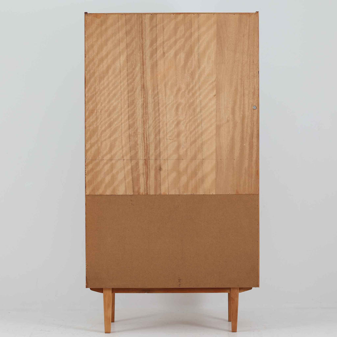 スウェーデン製のディスプレイシェルフです。上部は高さ調整可能な棚板が設けられており、書籍やオブジェの収納・展示に最適です。中央には小引き出しが2杯備わり、カトラリーや小物の整理にも便利。下部には扉付きの収納スペースがあり、日用品をすっきりと収納できます。素材にはチーク（本体）・オーク（脚の幕板）・ビーチ（脚）の3種の木材が用いられ、異なる木目のコントラストが美しい仕上がりです。北欧家具らしい温もりと実用性を兼ね備えた一台で、リビングやダイニング、書斎など幅広いシーンに調和します。