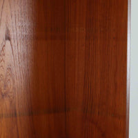 スウェーデン製のディスプレイシェルフです。上部は高さ調整可能な棚板が設けられており、書籍やオブジェの収納・展示に最適です。中央には小引き出しが2杯備わり、カトラリーや小物の整理にも便利。下部には扉付きの収納スペースがあり、日用品をすっきりと収納できます。素材にはチーク（本体）・オーク（脚の幕板）・ビーチ（脚）の3種の木材が用いられ、異なる木目のコントラストが美しい仕上がりです。北欧家具らしい温もりと実用性を兼ね備えた一台で、リビングやダイニング、書斎など幅広いシーンに調和します。