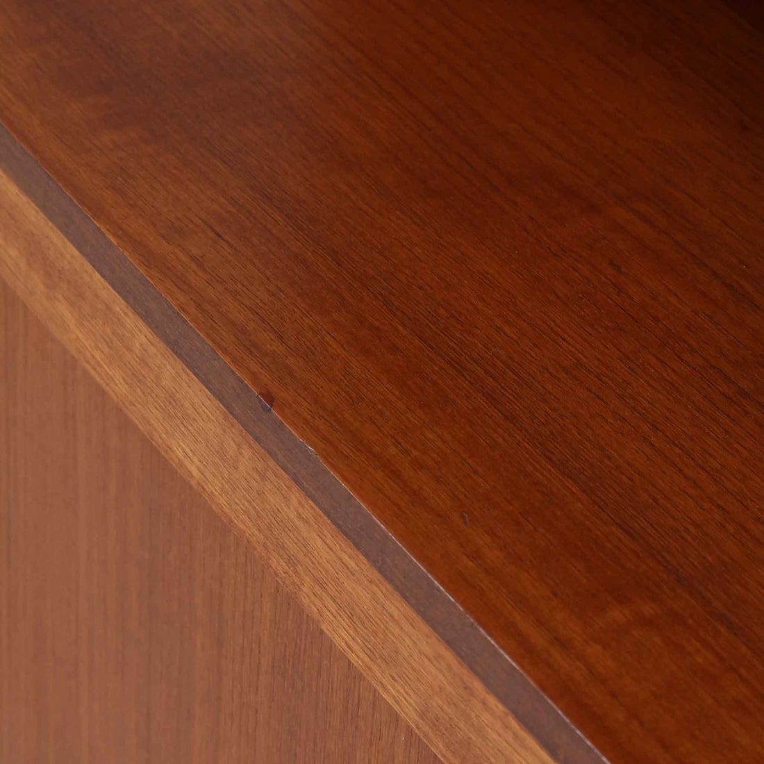 スウェーデン製のディスプレイシェルフです。上部は高さ調整可能な棚板が設けられており、書籍やオブジェの収納・展示に最適です。中央には小引き出しが2杯備わり、カトラリーや小物の整理にも便利。下部には扉付きの収納スペースがあり、日用品をすっきりと収納できます。素材にはチーク（本体）・オーク（脚の幕板）・ビーチ（脚）の3種の木材が用いられ、異なる木目のコントラストが美しい仕上がりです。北欧家具らしい温もりと実用性を兼ね備えた一台で、リビングやダイニング、書斎など幅広いシーンに調和します。