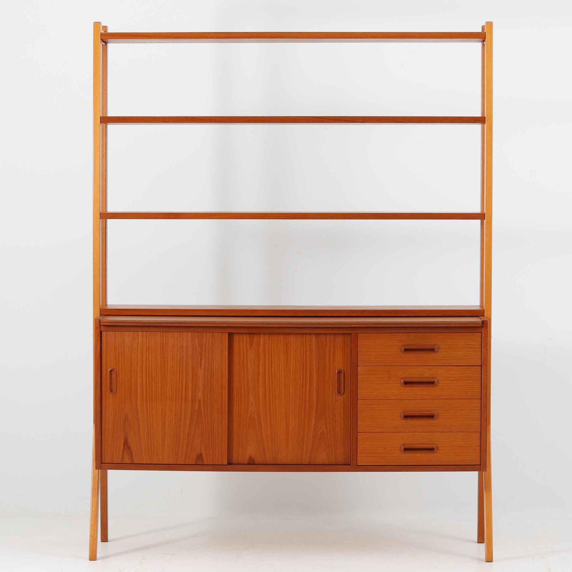 スウェーデン製のディスプレイシェルフで、チーク材とビーチ材の組み合わせが生み出す温かみと軽やかなコントラストが魅力です。上部はオープンな3段棚で開放感があり、お気に入りの雑貨や書籍をすっきりと美しく飾ることができます。下部には引き戸収納と4杯の引き出しを備え、日用品や小物を整理するのにも便利です。幅120cmと取り入れやすいサイズ感で、リビングやダイニングを軽やかに演出。経年による木肌の深みが加わり、シンプルながらも存在感を放つビンテージらしい一台です。