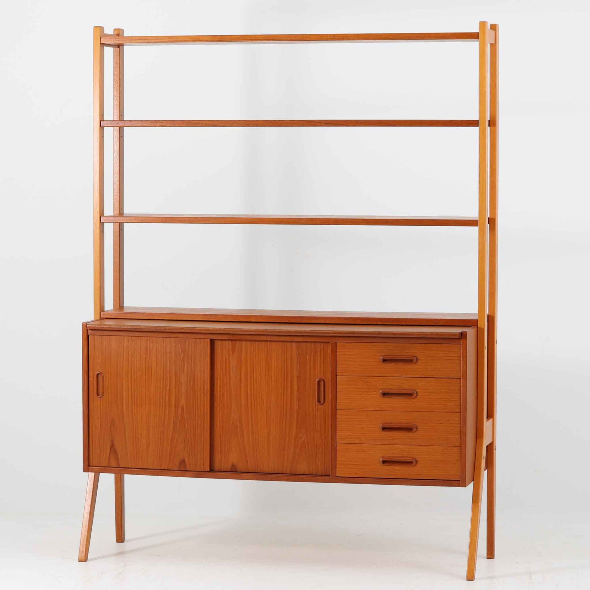 スウェーデン製のディスプレイシェルフで、チーク材とビーチ材の組み合わせが生み出す温かみと軽やかなコントラストが魅力です。上部はオープンな3段棚で開放感があり、お気に入りの雑貨や書籍をすっきりと美しく飾ることができます。下部には引き戸収納と4杯の引き出しを備え、日用品や小物を整理するのにも便利です。幅120cmと取り入れやすいサイズ感で、リビングやダイニングを軽やかに演出。経年による木肌の深みが加わり、シンプルながらも存在感を放つビンテージらしい一台です。