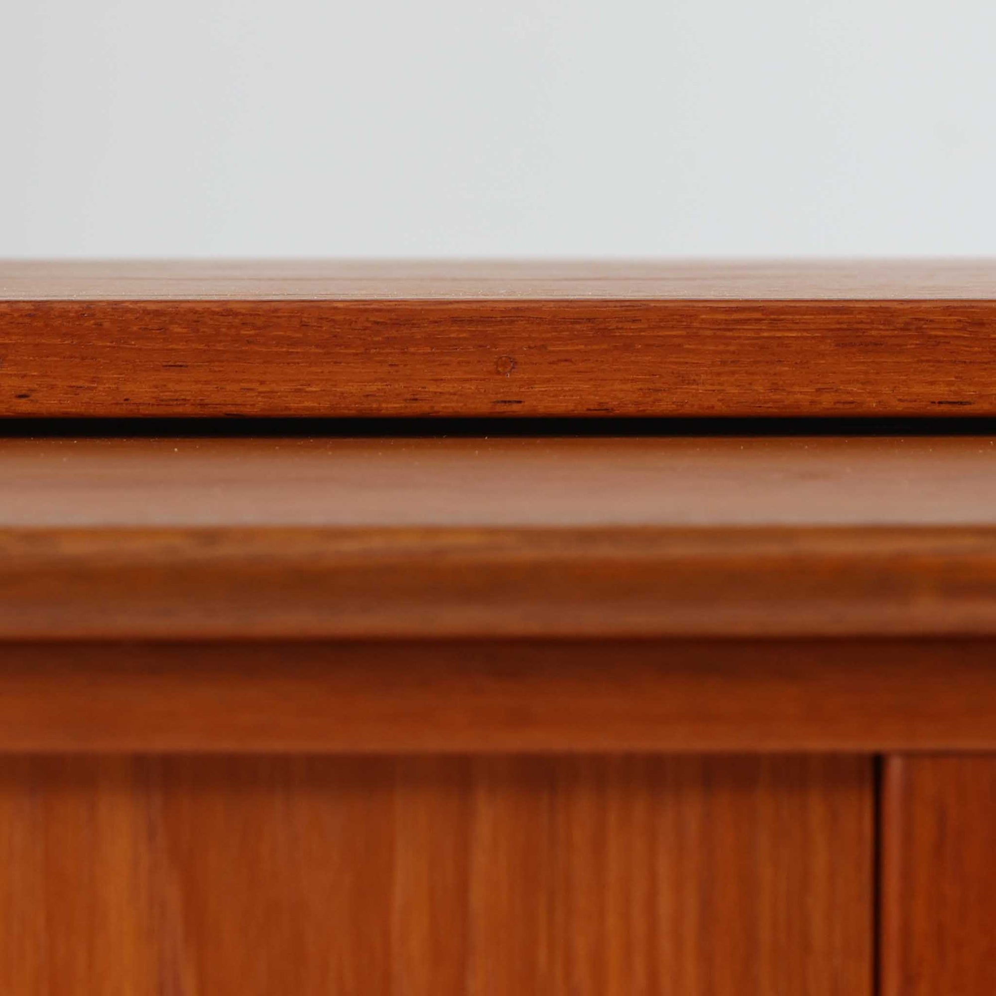 スウェーデン製のディスプレイシェルフで、チーク材とビーチ材の組み合わせが生み出す温かみと軽やかなコントラストが魅力です。上部はオープンな3段棚で開放感があり、お気に入りの雑貨や書籍をすっきりと美しく飾ることができます。下部には引き戸収納と4杯の引き出しを備え、日用品や小物を整理するのにも便利です。幅120cmと取り入れやすいサイズ感で、リビングやダイニングを軽やかに演出。経年による木肌の深みが加わり、シンプルながらも存在感を放つビンテージらしい一台です。