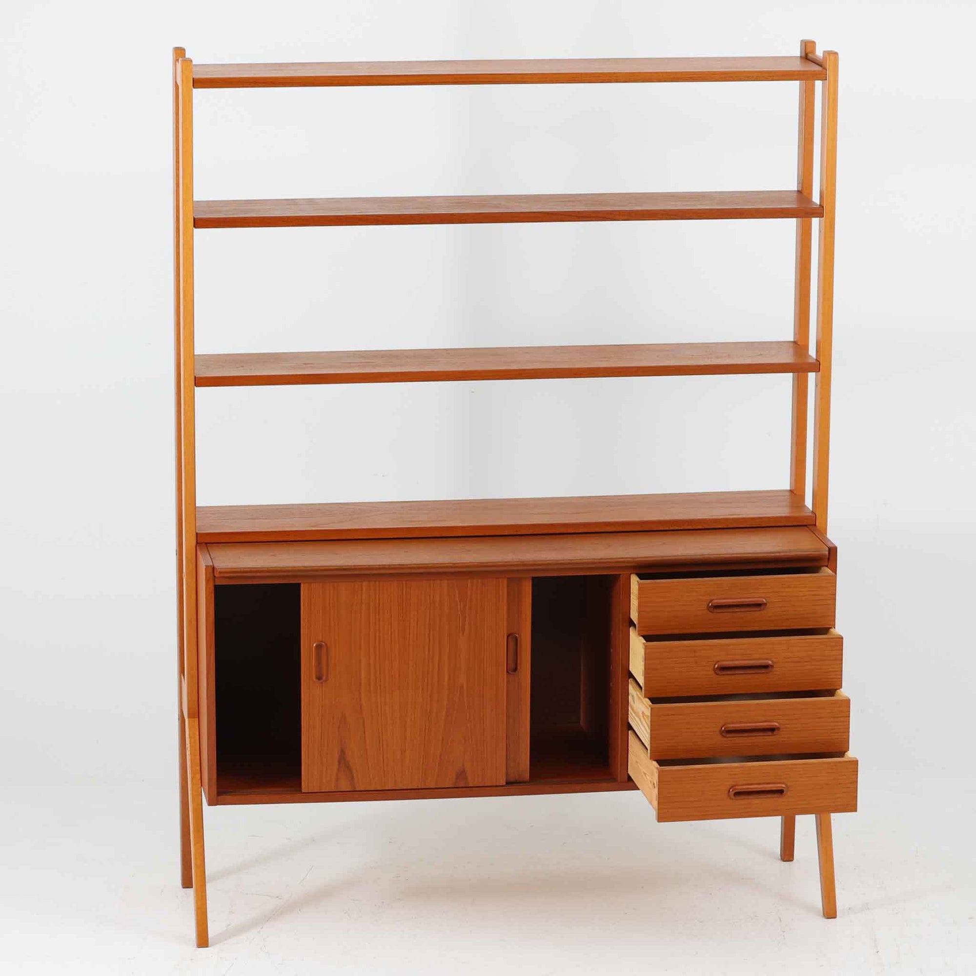 スウェーデン製のディスプレイシェルフで、チーク材とビーチ材の組み合わせが生み出す温かみと軽やかなコントラストが魅力です。上部はオープンな3段棚で開放感があり、お気に入りの雑貨や書籍をすっきりと美しく飾ることができます。下部には引き戸収納と4杯の引き出しを備え、日用品や小物を整理するのにも便利です。幅120cmと取り入れやすいサイズ感で、リビングやダイニングを軽やかに演出。経年による木肌の深みが加わり、シンプルながらも存在感を放つビンテージらしい一台です。