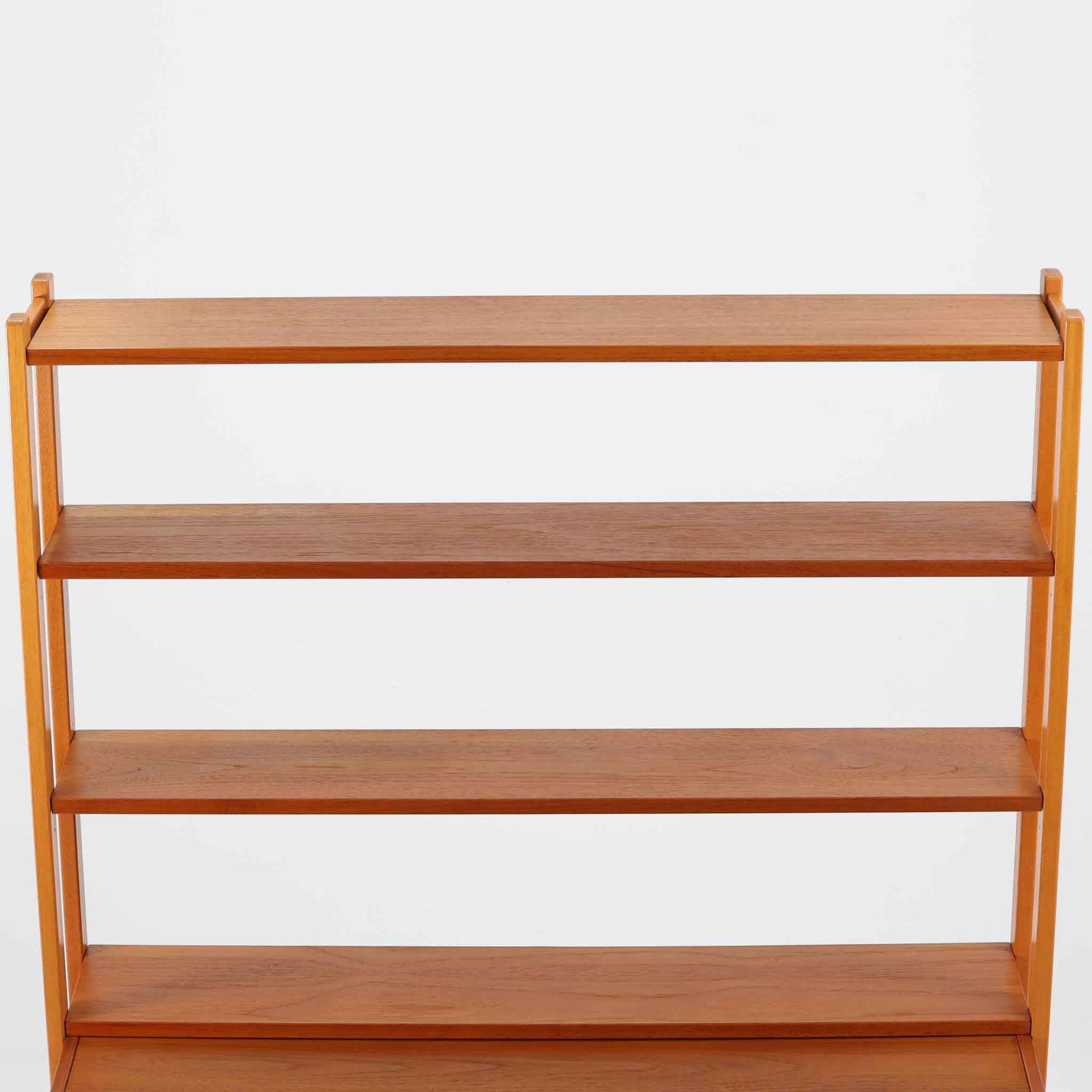 スウェーデン製のディスプレイシェルフで、チーク材とビーチ材の組み合わせが生み出す温かみと軽やかなコントラストが魅力です。上部はオープンな3段棚で開放感があり、お気に入りの雑貨や書籍をすっきりと美しく飾ることができます。下部には引き戸収納と4杯の引き出しを備え、日用品や小物を整理するのにも便利です。幅120cmと取り入れやすいサイズ感で、リビングやダイニングを軽やかに演出。経年による木肌の深みが加わり、シンプルながらも存在感を放つビンテージらしい一台です。