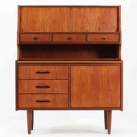 デンマーク製のビンテージライティングビューロです。チーク材を使用した温かみのある木肌と美しい木目が印象的で、北欧家具ならではの上質な存在感を放ちます。上部の引き戸収納や小引き出し、下部の引き出しとキャビネットを備え、機能的に整理できる実用的な設計が魅力。天板をデスクとして使えるため、書き物や作業スペースとしても活躍します。丸みを帯びたフォルムや細身の脚部が軽やかな印象を与え、経年により深みを増したチークの風合いがビンテージ家具ならではの味わいを楽しめる一台です。