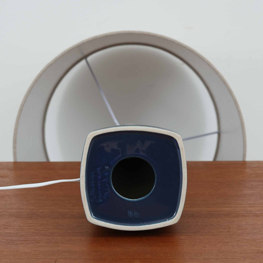 スーホルム・セラミック社製のこちらのテーブルランプは、高さ57cmと存在感のあるサイズ感が魅力の北欧ビンテージ品です。陶磁器のベースは、深みのあるブルーからブラウンへの美しい釉薬のグラデーションが特徴で、すっきりと伸びるシルエットが空間にモダンな印象を与えます。リネンシェードを透した柔らかな光はリビングや寝室を心地よく照らし、年月を経て味わいを増した質感が一点物の魅力を際立たせます。北欧インテリアのアクセントとしておすすめの逸品です。