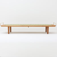Hans J. Wegner（ハンス・J・ウェグナー）がGetama社のために手掛けたGE19 ベンチソファは、端正なプロポーションと素材使いが際立つ北欧ビンテージの名作です。フレームにはオーク材を用い、細身で安定感のある脚部と、両端に配されたメタルパーツが軽やかなアクセントとなっています。マットレスやクッションを合わせることで、ベンチとしてもベッドとしても幅広く活用可能です。経年により深みを増した木肌と、当時の職人技が感じられる構造が、空間に静かな存在感と上質な佇まいをもたらします。