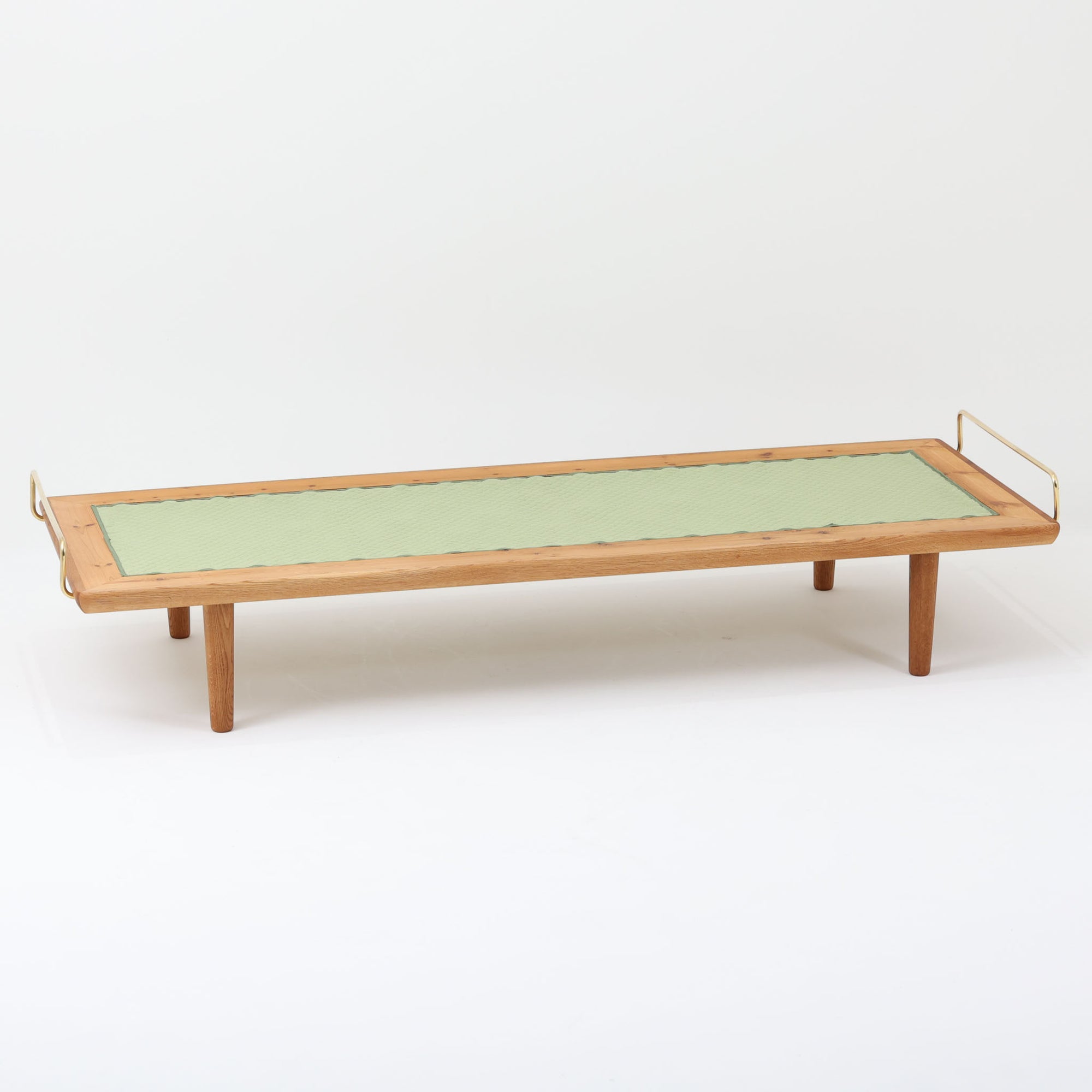 Hans J. Wegner（ハンス・J・ウェグナー）がGetama社のために手掛けたGE19 ベンチソファは、端正なプロポーションと素材使いが際立つ北欧ビンテージの名作です。フレームにはオーク材を用い、細身で安定感のある脚部と、両端に配されたメタルパーツが軽やかなアクセントとなっています。マットレスやクッションを合わせることで、ベンチとしてもベッドとしても幅広く活用可能です。経年により深みを増した木肌と、当時の職人技が感じられる構造が、空間に静かな存在感と上質な佇まいをもたらします。