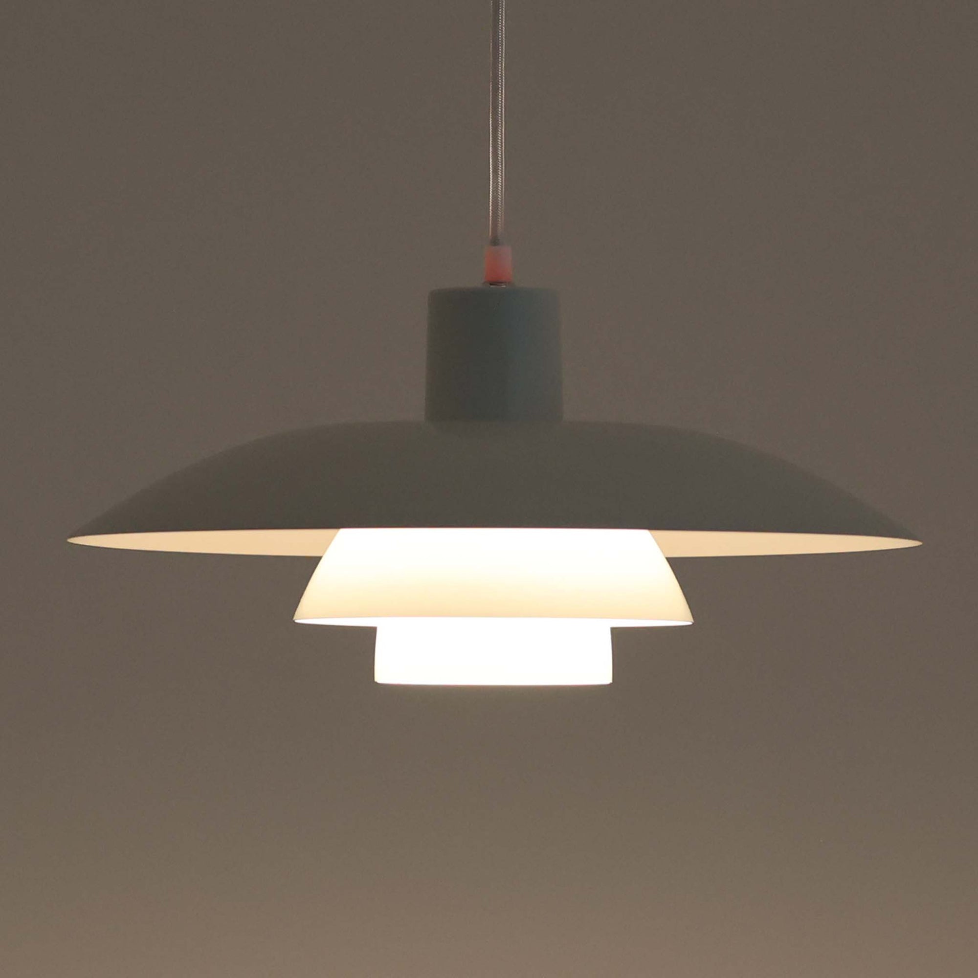 北欧より買い付けたLouis Poulsen社製「PH4」は、Poul Henningsenによる名作照明で、直径40cmの程よいサイズとアルミの軽やかな質感が魅力です。PH5と並ぶ人気を誇り、3枚シェード構造が光を柔らかく拡散し落ち着いた空間を演出します。経年の風合いも楽しめ、ダイニングやリビング、書斎や寝室まで幅広く活躍するビンテージ品です。