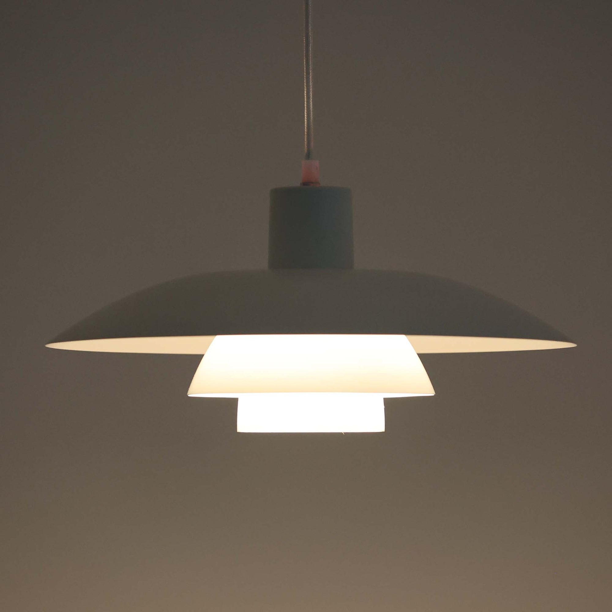 北欧より買い付けたLouis Poulsen社製「PH4」は、Poul Henningsenによる名作照明で、直径40cmの程よいサイズとアルミの軽やかな質感が魅力です。PH5と並ぶ人気を誇り、3枚シェード構造が光を柔らかく拡散し落ち着いた空間を演出します。経年の風合いも楽しめ、ダイニングやリビング、書斎や寝室まで幅広く活躍するビンテージ品です。