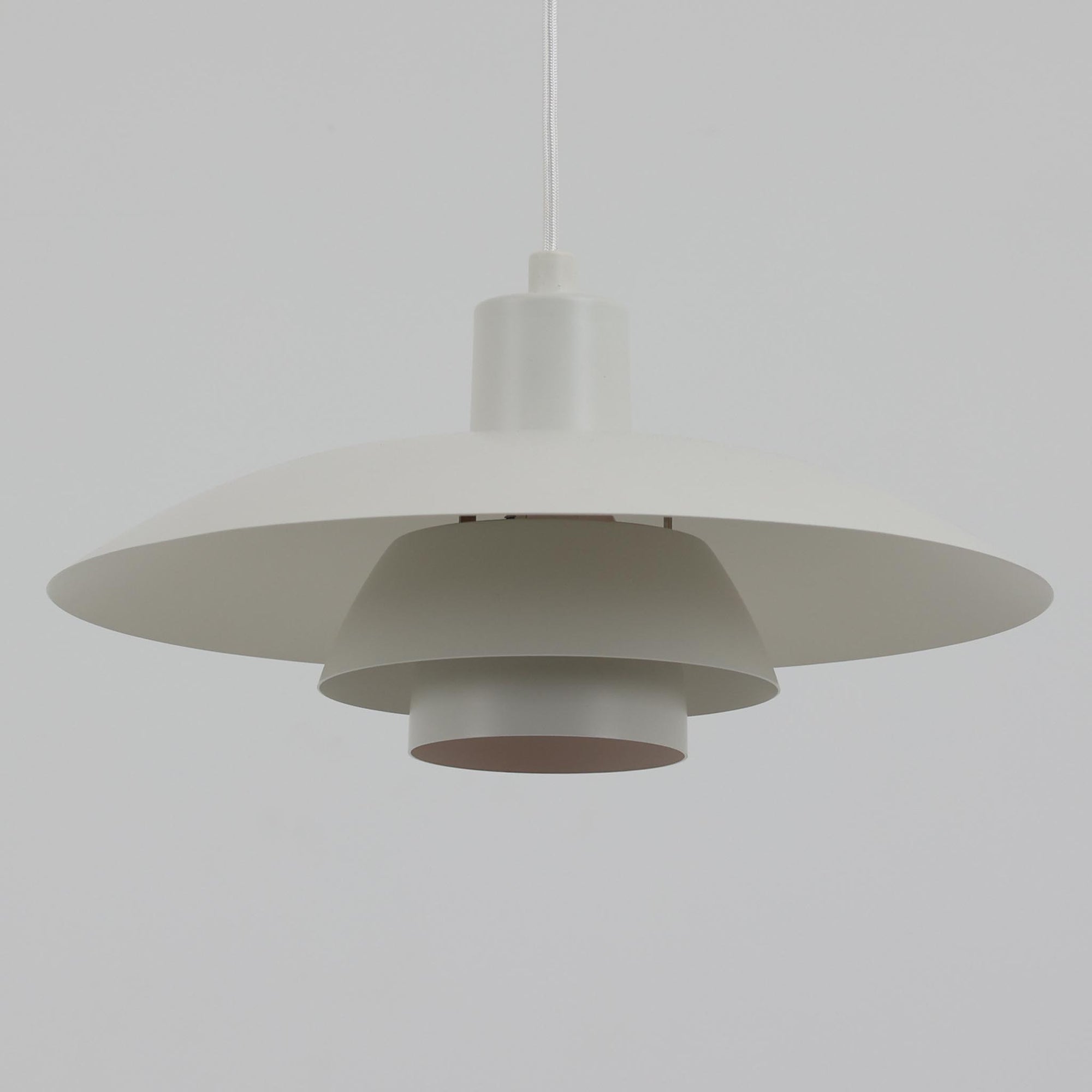 北欧より買い付けたLouis Poulsen社製「PH4」は、Poul Henningsenによる名作照明で、直径40cmの程よいサイズとアルミの軽やかな質感が魅力です。PH5と並ぶ人気を誇り、3枚シェード構造が光を柔らかく拡散し落ち着いた空間を演出します。経年の風合いも楽しめ、ダイニングやリビング、書斎や寝室まで幅広く活躍するビンテージ品です。