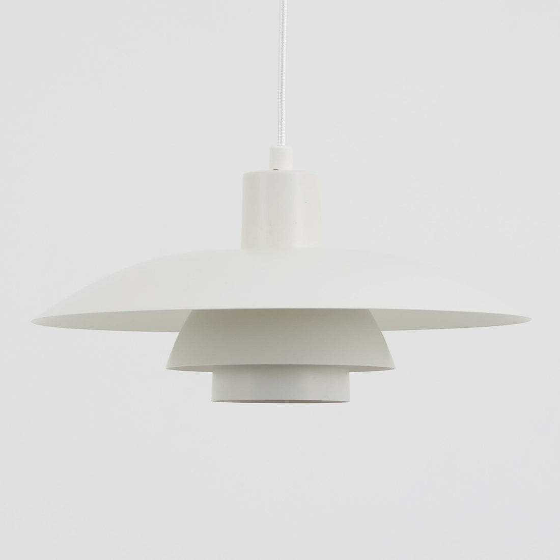 北欧より買い付けたLouis Poulsen社製「PH4」は、Poul Henningsenによる名作照明で、直径40cmの程よいサイズとアルミの軽やかな質感が魅力です。PH5と並ぶ人気を誇り、3枚シェード構造が光を柔らかく拡散し落ち着いた空間を演出します。経年の風合いも楽しめ、ダイニングやリビング、書斎や寝室まで幅広く活躍するビンテージ品です。