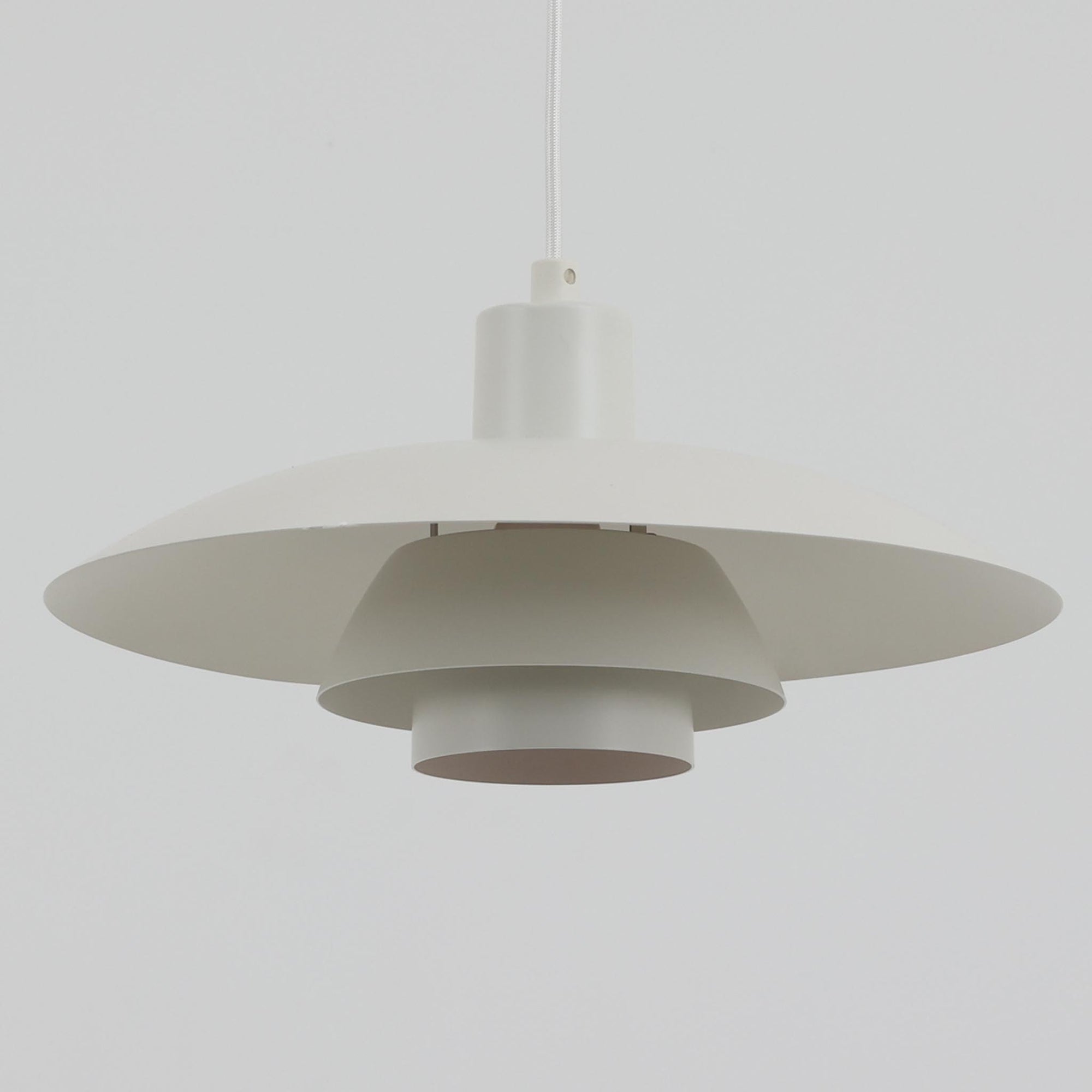 北欧より買い付けたLouis Poulsen社製「PH4」は、Poul Henningsenによる名作照明で、直径40cmの程よいサイズとアルミの軽やかな質感が魅力です。PH5と並ぶ人気を誇り、3枚シェード構造が光を柔らかく拡散し落ち着いた空間を演出します。経年の風合いも楽しめ、ダイニングやリビング、書斎や寝室まで幅広く活躍するビンテージ品です。