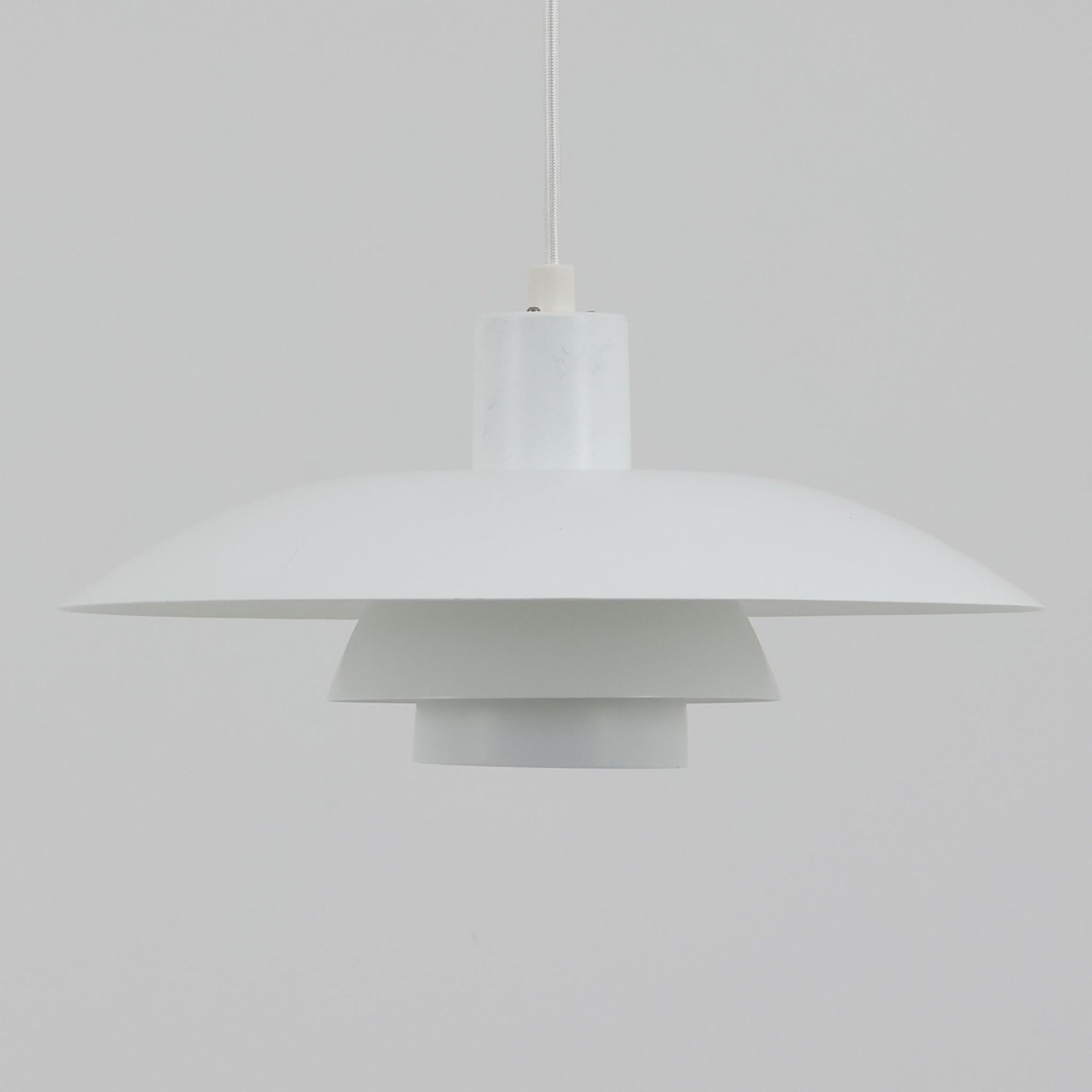 北欧より買い付けたLouis Poulsen社製「PH4」は、Poul Henningsenによる名作照明で、直径40cmの程よいサイズとアルミの軽やかな質感が魅力です。PH5と並ぶ人気を誇り、3枚シェード構造が光を柔らかく拡散し落ち着いた空間を演出します。経年の風合いも楽しめ、ダイニングやリビング、書斎や寝室まで幅広く活躍するビンテージ品です。