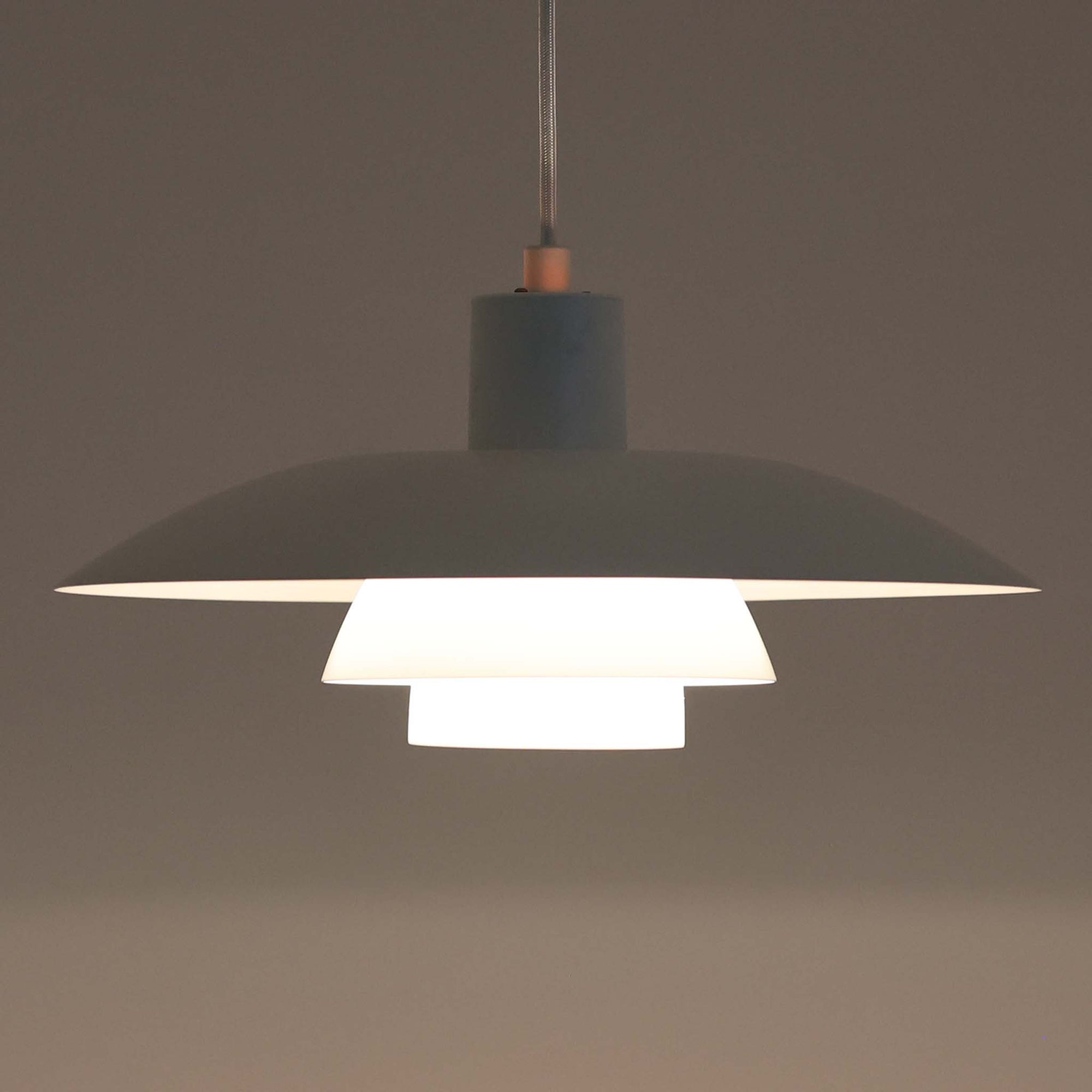 北欧より買い付けたLouis Poulsen社製「PH4」は、Poul Henningsenによる名作照明で、直径40cmの程よいサイズとアルミの軽やかな質感が魅力です。PH5と並ぶ人気を誇り、3枚シェード構造が光を柔らかく拡散し落ち着いた空間を演出します。経年の風合いも楽しめ、ダイニングやリビング、書斎や寝室まで幅広く活躍するビンテージ品です。