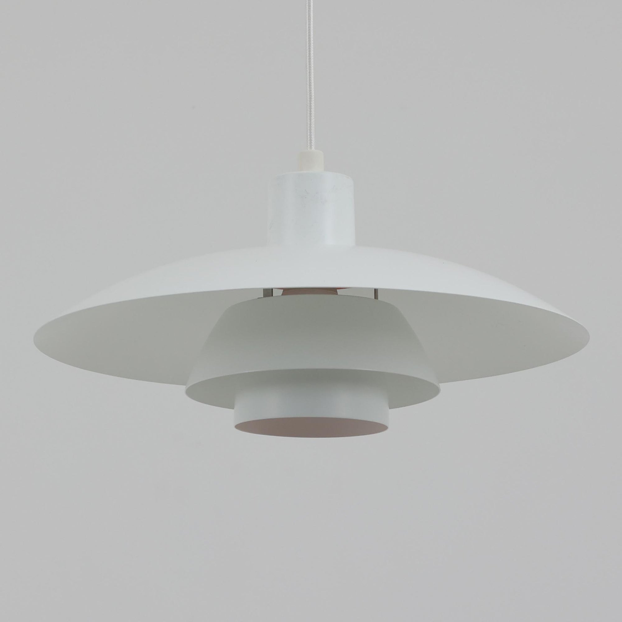 北欧より買い付けたLouis Poulsen社製「PH4」は、Poul Henningsenによる名作照明で、直径40cmの程よいサイズとアルミの軽やかな質感が魅力です。PH5と並ぶ人気を誇り、3枚シェード構造が光を柔らかく拡散し落ち着いた空間を演出します。経年の風合いも楽しめ、ダイニングやリビング、書斎や寝室まで幅広く活躍するビンテージ品です。