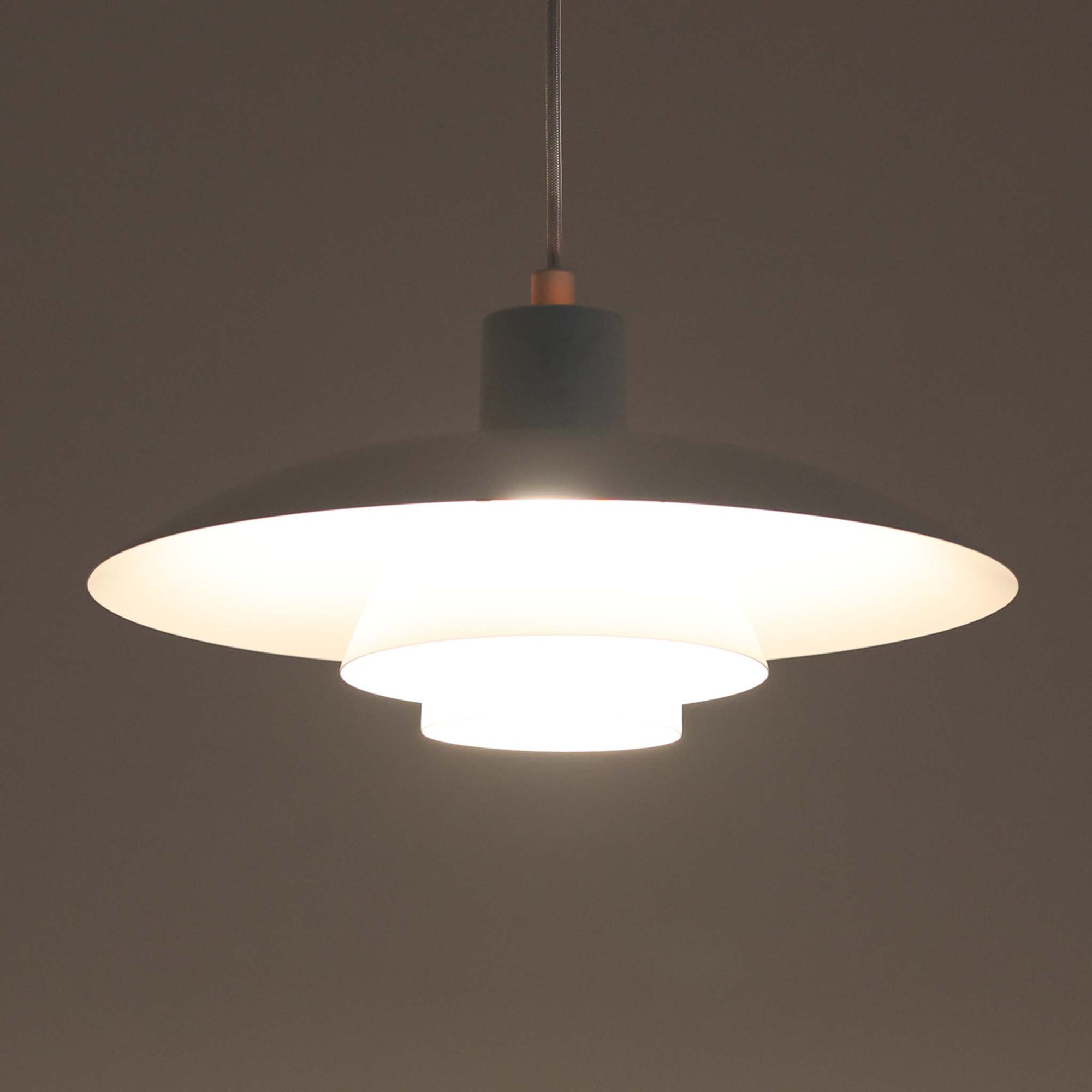 北欧より買い付けたLouis Poulsen社製「PH4」は、Poul Henningsenによる名作照明で、直径40cmの程よいサイズとアルミの軽やかな質感が魅力です。PH5と並ぶ人気を誇り、3枚シェード構造が光を柔らかく拡散し落ち着いた空間を演出します。経年の風合いも楽しめ、ダイニングやリビング、書斎や寝室まで幅広く活躍するビンテージ品です。