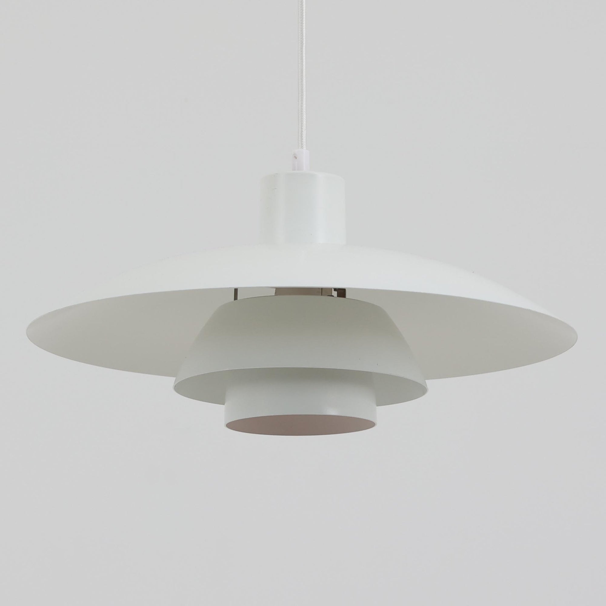 北欧より買い付けたLouis Poulsen社製「PH4」は、Poul Henningsenによる名作照明で、直径40cmの程よいサイズとアルミの軽やかな質感が魅力です。PH5と並ぶ人気を誇り、3枚シェード構造が光を柔らかく拡散し落ち着いた空間を演出します。経年の風合いも楽しめ、ダイニングやリビング、書斎や寝室まで幅広く活躍するビンテージ品です。