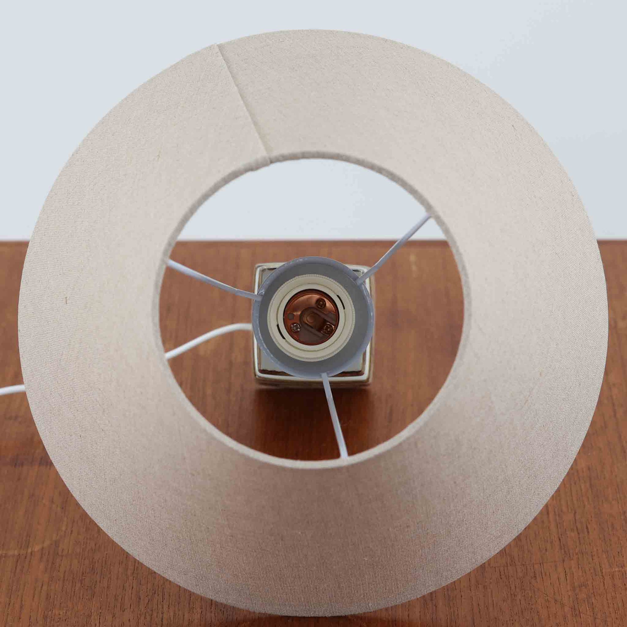 Nils Thorssonがデザインし、Royal Copenhagen社から発表された「BACA」シリーズのテーブルランプは、高さ38cmのバランスの取れたサイズ感で、北欧ビンテージらしい存在感を放ちます。陶磁器製のベースには細やかな装飾模様が施され、グラフィカルでありながら落ち着いた色調が空間に洗練された雰囲気を添えます。リネンシェードを透過する柔らかな光が温もりを演出し、リビングやベッドサイドに最適です。年月を経て深みを増した質感と工芸的な美しさを楽しめる一点物です。