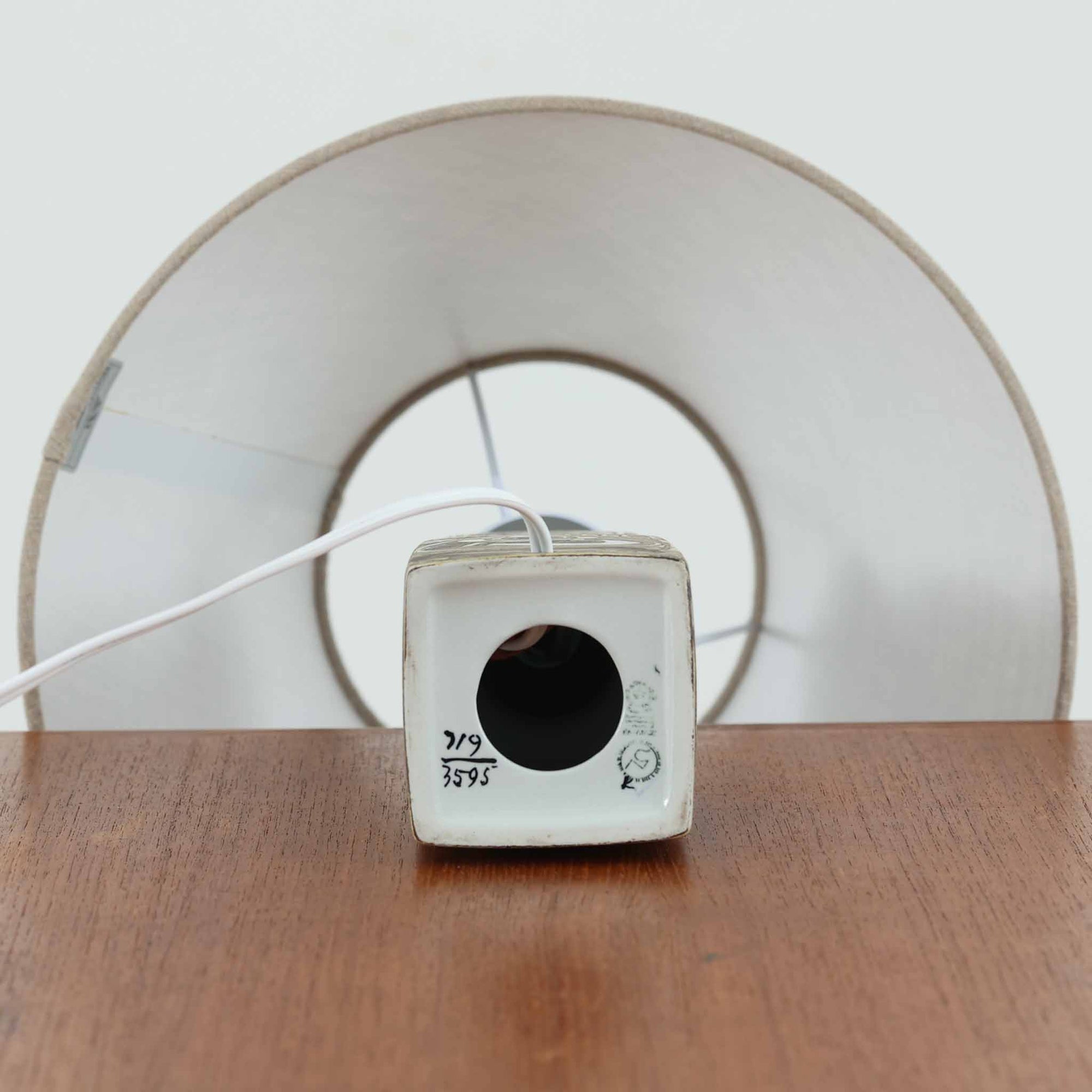 Nils Thorssonがデザインし、Royal Copenhagen社から発表された「BACA」シリーズのテーブルランプは、高さ38cmのバランスの取れたサイズ感で、北欧ビンテージらしい存在感を放ちます。陶磁器製のベースには細やかな装飾模様が施され、グラフィカルでありながら落ち着いた色調が空間に洗練された雰囲気を添えます。リネンシェードを透過する柔らかな光が温もりを演出し、リビングやベッドサイドに最適です。年月を経て深みを増した質感と工芸的な美しさを楽しめる一点物です。