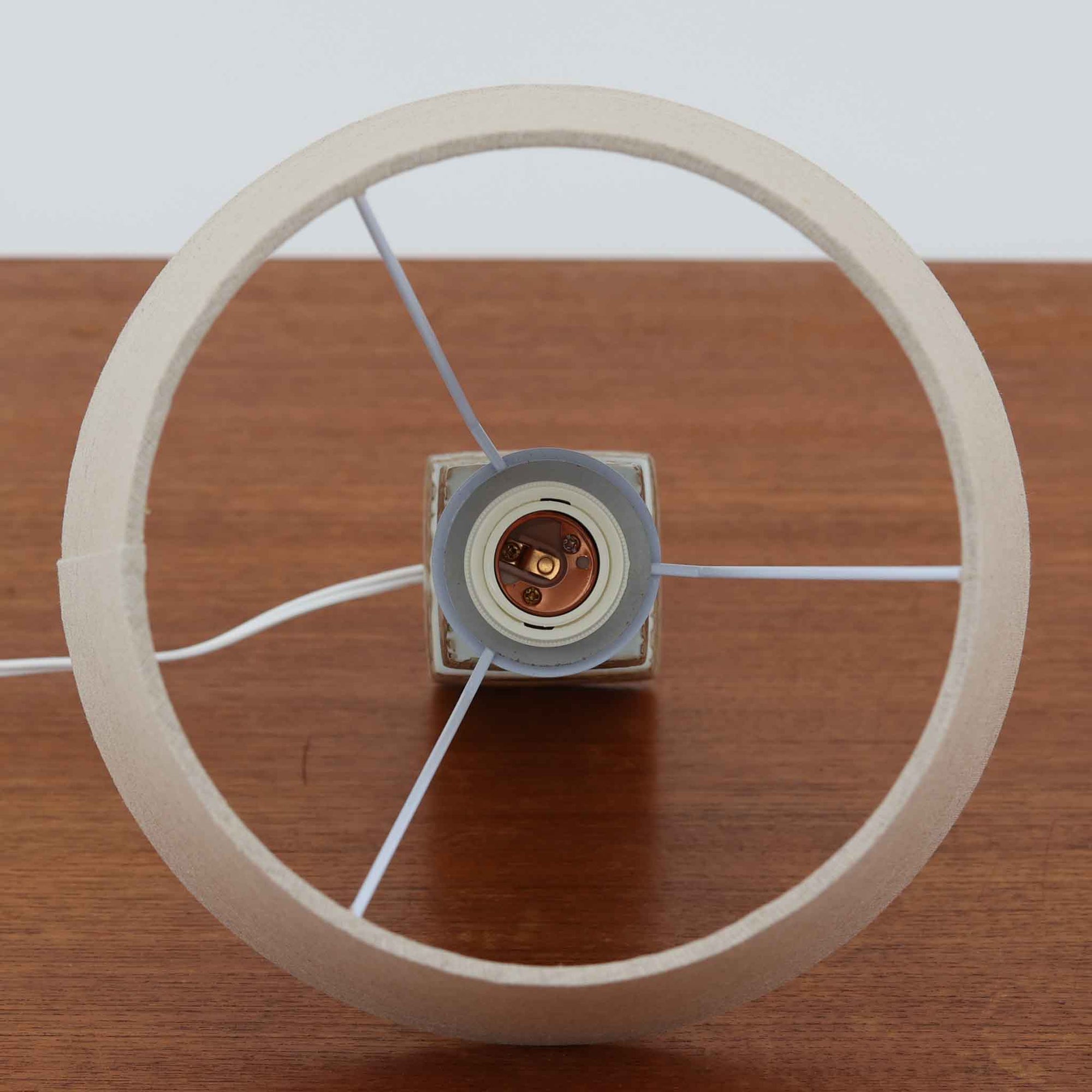 Nils Thorssonがデザインし、Royal Copenhagen社から発表された「BACA」シリーズのテーブルランプは、高さ39cmのバランスの取れたサイズ感で、北欧ビンテージらしい存在感を放ちます。陶磁器製のベースには細やかな装飾模様が施され、グラフィカルでありながら落ち着いた色調が空間に洗練された雰囲気を添えます。リネンシェードを透過する柔らかな光が温もりを演出し、リビングやベッドサイドに最適です。年月を経て深みを増した質感と工芸的な美しさを楽しめる一点物です。