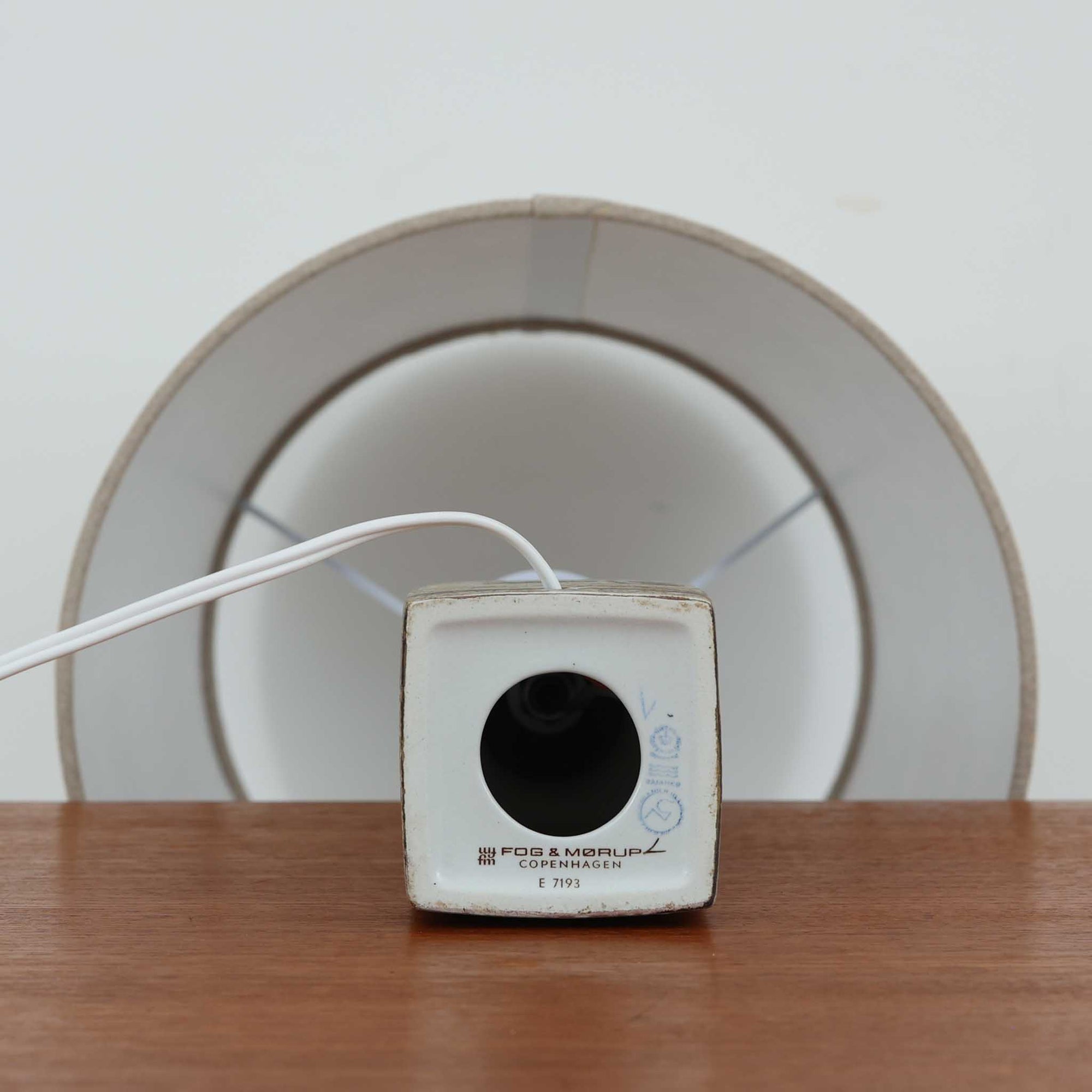 Nils Thorssonがデザインし、Royal Copenhagen社から発表された「BACA」シリーズのテーブルランプは、高さ39cmのバランスの取れたサイズ感で、北欧ビンテージらしい存在感を放ちます。陶磁器製のベースには細やかな装飾模様が施され、グラフィカルでありながら落ち着いた色調が空間に洗練された雰囲気を添えます。リネンシェードを透過する柔らかな光が温もりを演出し、リビングやベッドサイドに最適です。年月を経て深みを増した質感と工芸的な美しさを楽しめる一点物です。