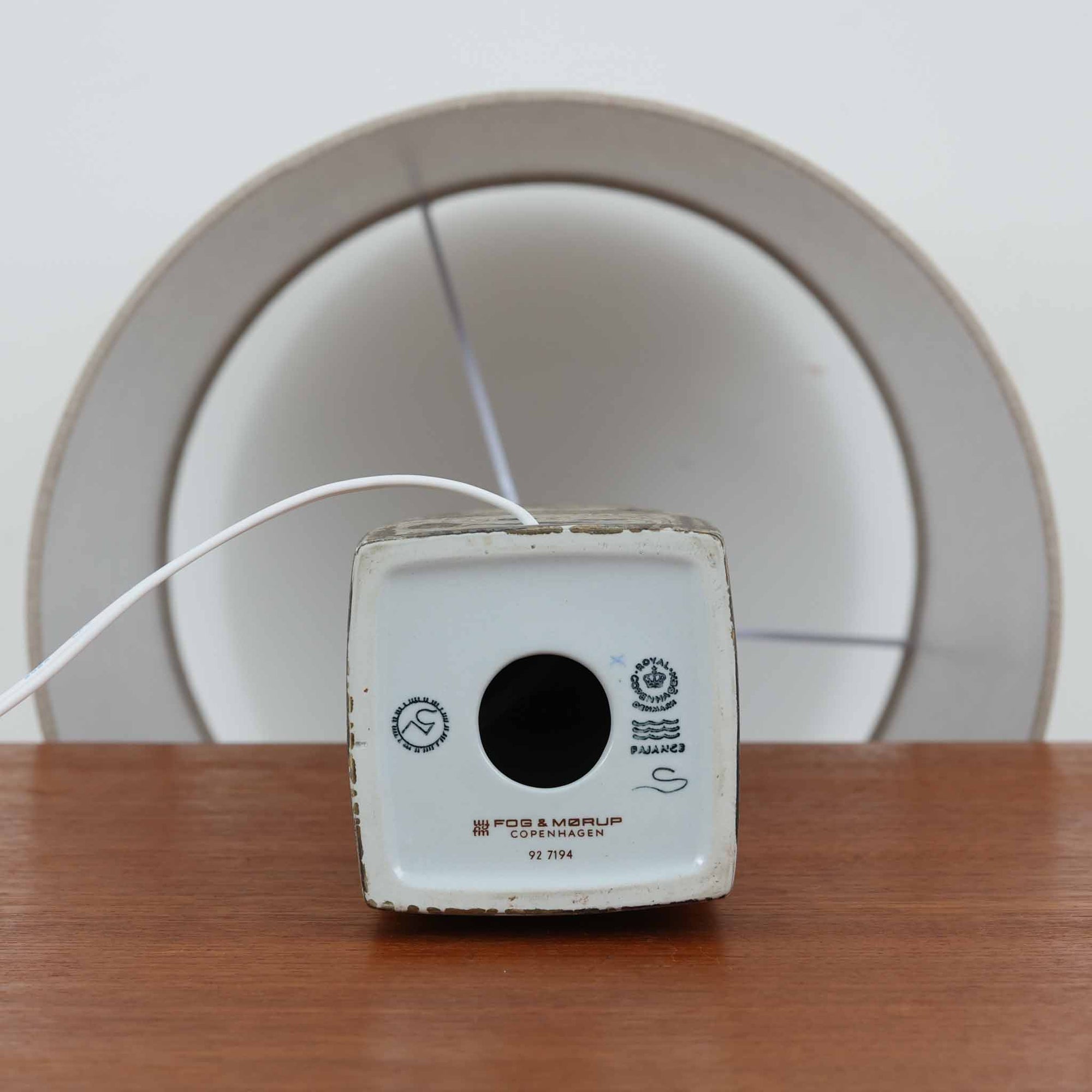 Nils ThorssonによるRoyal Copenhagen社のBACAシリーズのテーブルランプは、高さ50cmと大ぶりで存在感のあるビンテージアイテムです。陶磁器のベースにはトールソンらしい細密な装飾パターンが施され、幾何学的でありながら有機的なモチーフが調和し、芸術性を感じさせます。リネンシェードを透す光は柔らかく広がり、リビングや寝室を温かく包み込みます。年月を経た釉薬の風合いとクラフト感が、北欧ビンテージならではの魅力を引き立てる逸品です。