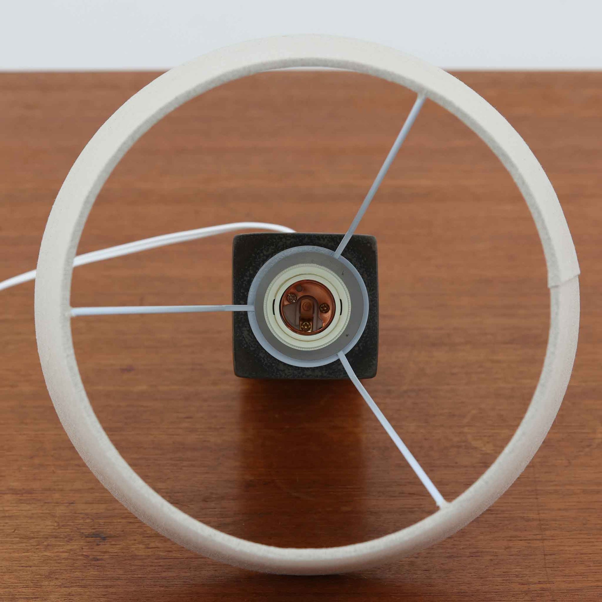 Nils Thorssonが手掛けたRoyal Copenhagen社BACAシリーズのテーブルランプは、高さ41cmの程よいサイズ感で空間に上質な存在感を与えます。陶磁器のベースには幾何学的で抽象的なモチーフが施され、複雑な釉薬の表情が芸術性を引き立てています。シンプルなリネンシェードを透した光は柔らかく広がり、リビングやベッドサイドを温かみのある雰囲気に演出。クラフトマンシップとデザイン性が融合した北欧ビンテージの魅力を存分に味わえる逸品です。