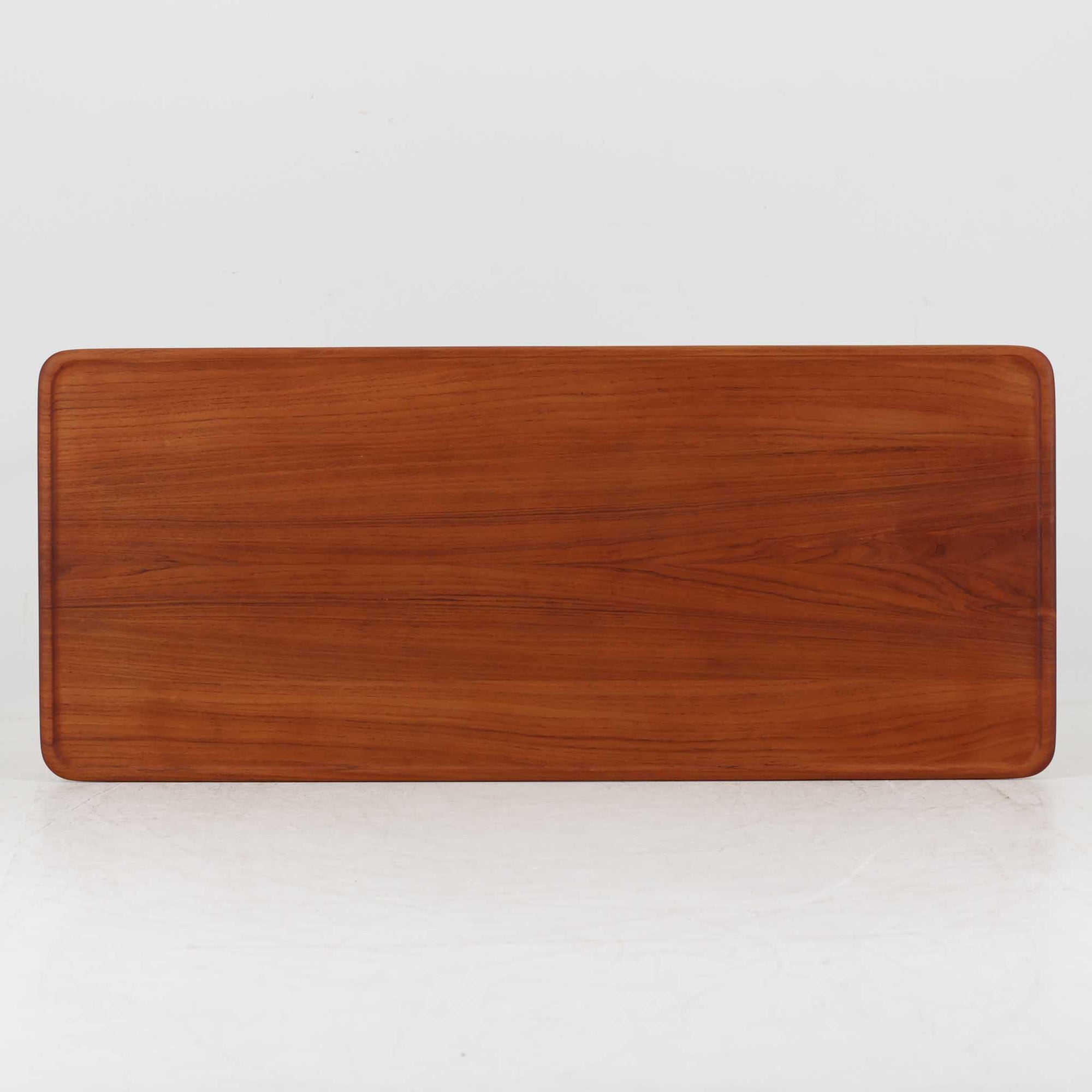 Hans J. Wegner（ハンス・J・ウェグナー）によるAndreas Tuck社製のセンターテーブル「AT11」です。幅130cmの広々とした天板はチーク無垢材を使用し、縁には繊細な面取り加工が施され、柔らかな印象を与えます。脚部には堅牢なオーク無垢材が用いられ、軽やかなテーパードデザインが北欧家具らしいバランスの良さを感じさせます。さらに脚のネジ部分まで木製で仕上げられており、細部に至るまで職人技が光る逸品です。脚は取り外し可能な構造で、輸送や設置も容易です。シンプルでありながら素材の美しさが際立ち、経年変化による深みを増した木肌がビンテージならではの存在感を放ちます。リビングの中心に置いて使うことで、空間に上質な雰囲気を添える一台です。