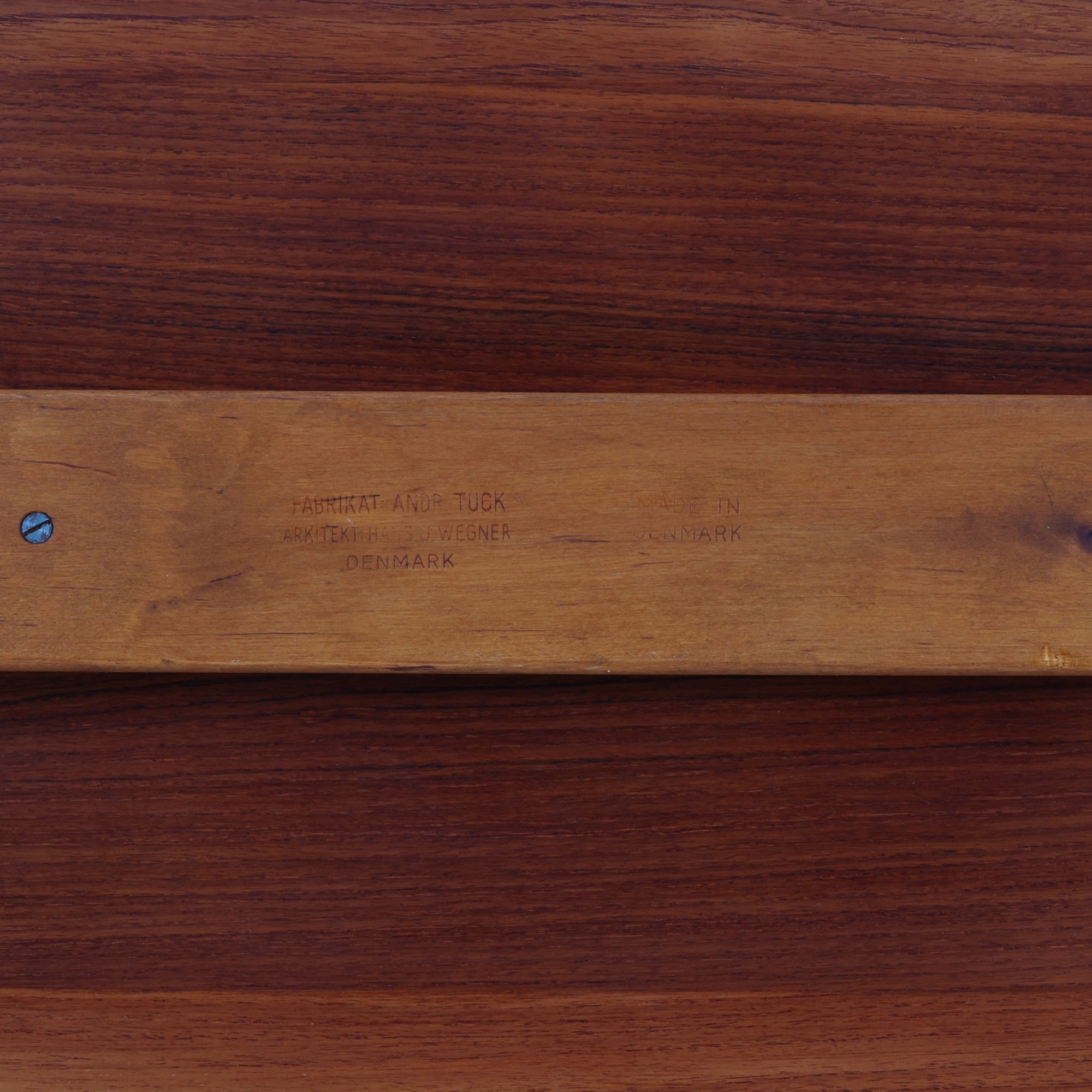 Hans J. Wegner（ハンス・J・ウェグナー）によるAndreas Tuck社製のセンターテーブル「AT11」です。幅130cmの広々とした天板はチーク無垢材を使用し、縁には繊細な面取り加工が施され、柔らかな印象を与えます。脚部には堅牢なオーク無垢材が用いられ、軽やかなテーパードデザインが北欧家具らしいバランスの良さを感じさせます。さらに脚のネジ部分まで木製で仕上げられており、細部に至るまで職人技が光る逸品です。脚は取り外し可能な構造で、輸送や設置も容易です。シンプルでありながら素材の美しさが際立ち、経年変化による深みを増した木肌がビンテージならではの存在感を放ちます。リビングの中心に置いて使うことで、空間に上質な雰囲気を添える一台です。