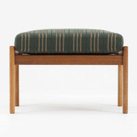 Hans J. Wegnerがデザインし、Getamaが製作したGE290オットマンの希少なサイドテーブル兼用タイプです。オーク材の美しい木目を活かしたフレームは、丸みを帯びたアーム状の意匠が印象的で、安定感のある堅牢な構造が魅力。クッションを外せばトレーテーブルとしても使用できる実用的な設計です。本品はGetama社の刻印が入る以前の古いタイプで、初期モデルならではの佇まいも価値を高めています。ラウンジチェアと合わせてはもちろん、単体でも存在感を放つ北欧ビンテージの逸品です。クッション内部にはビンテージ品ならではのスプリングが内包されています。