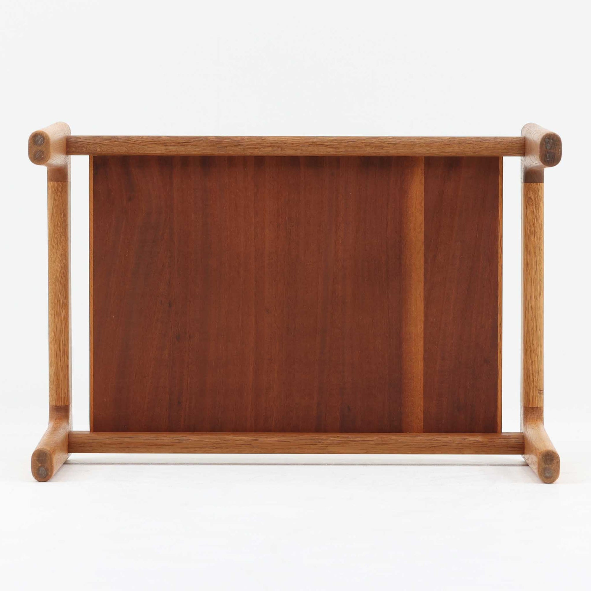 Hans J. Wegnerがデザインし、Getamaが製作したGE290オットマンの希少なサイドテーブル兼用タイプです。オーク材の美しい木目を活かしたフレームは、丸みを帯びたアーム状の意匠が印象的で、安定感のある堅牢な構造が魅力。クッションを外せばトレーテーブルとしても使用できる実用的な設計です。本品はGetama社の刻印が入る以前の古いタイプで、初期モデルならではの佇まいも価値を高めています。ラウンジチェアと合わせてはもちろん、単体でも存在感を放つ北欧ビンテージの逸品です。クッション内部にはビンテージ品ならではのスプリングが内包されています。