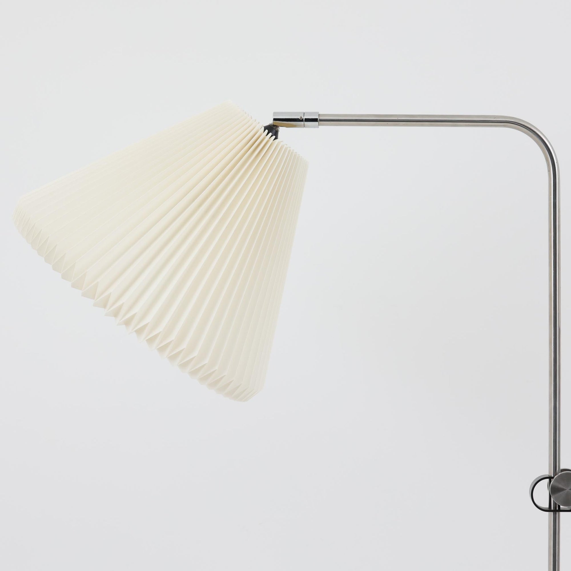 Michael Bang（マイケル・バン）によるデザインで、Le Klint（レ・クリント）から発表されたフロアランプModel 321です。高さ131cmのスチール製フレームは、無駄のない直線的なフォルムと精巧なディテールが際立ち、モダンな空間に調和します。特徴的なスライド機構によりランプの高さを調整でき、読書灯から間接照明まで幅広い用途に対応。ハンドクラフトによるプリーツシェードは柔らかい光を生み出し、北欧ビンテージならではの温もりと機能美を感じさせます。