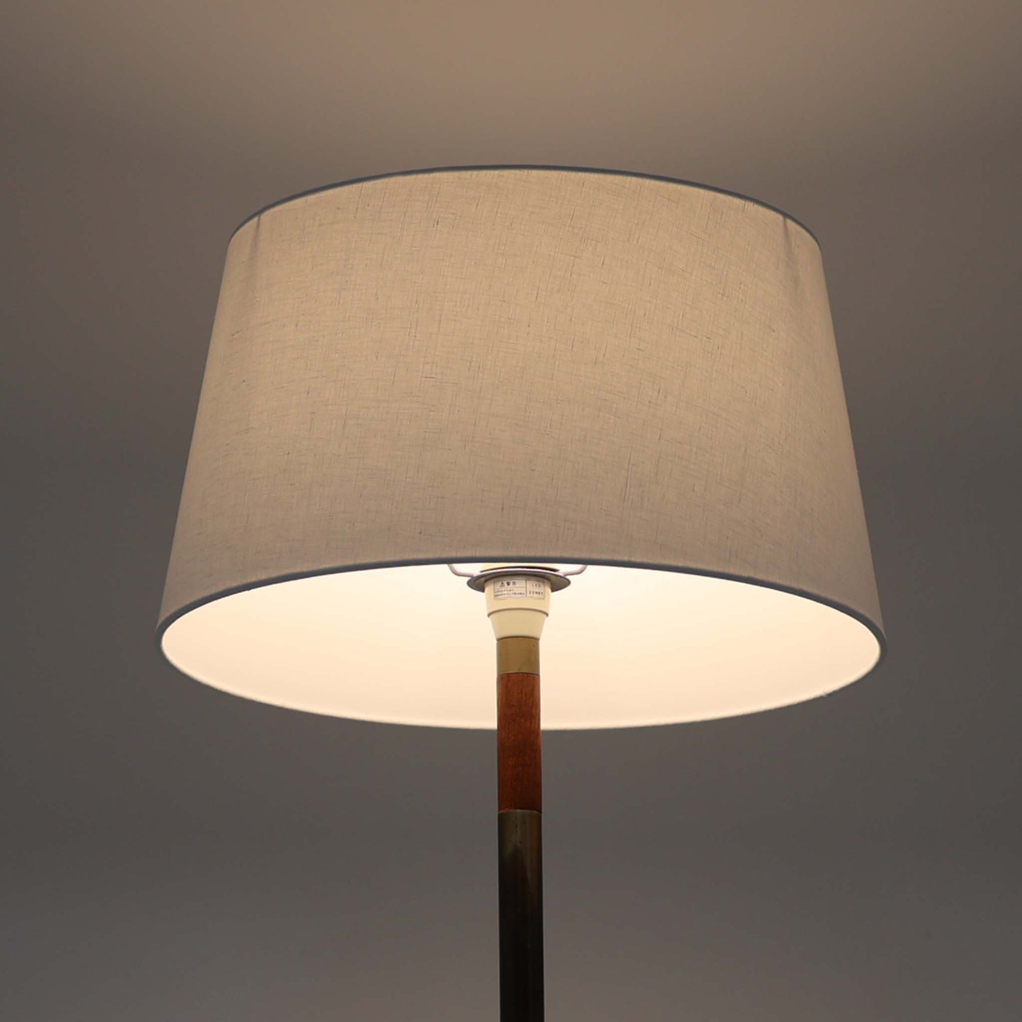 Jo HammerborgがFog &amp; Morupのために手がけた「Monolit」は、真鍮のシャフトにチーク材のアクセントを加えたミニマルで洗練されたフロアランプです。高さ164cmの堂々たるプロポーションに、Y字型の真鍮ベースが独自の存在感を放ち、リネンシェードを通した柔らかな光が空間に落ち着きを与えます。素材のコントラストと構造美が際立つ一台は、北欧ビンテージ照明の中でも特に希少な逸品といえるでしょう。