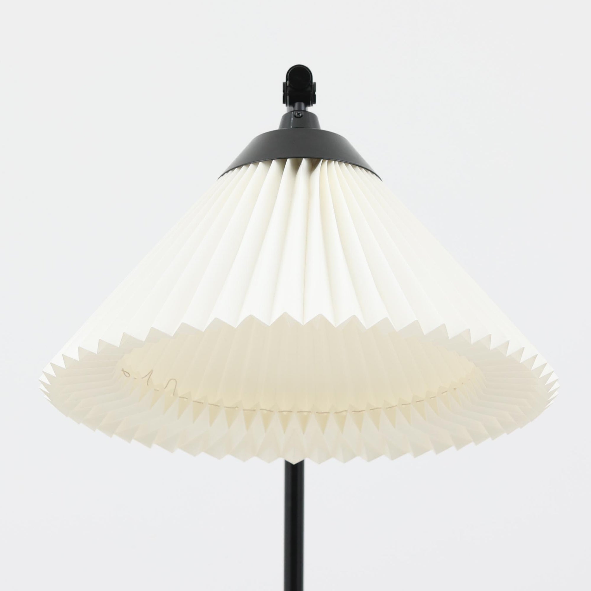 Flemming Agger（フレミング・アガー）がデザインし、Le Klint（レ・クリント）社より発表されたモデル368のフロアランプです。高さ145cmのスマートなフォルムに、ブラックスチールのアームと美しいプリーツシェードが組み合わされ、北欧モダンらしい端正な佇まいを見せます。プラスチックシート製のシェードは光を柔らかく透過し、リビングやベッドサイドに心地よい明かりをもたらします。シンプルながらも計算された構造は職人技が感じられ、ビンテージならではの希少性と存在感を併せ持つ逸品です。