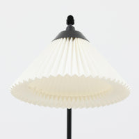 Flemming Agger（フレミング・アガー）がデザインし、Le Klint（レ・クリント）社より発表されたモデル368のフロアランプです。高さ145cmのスマートなフォルムに、ブラックスチールのアームと美しいプリーツシェードが組み合わされ、北欧モダンらしい端正な佇まいを見せます。プラスチックシート製のシェードは光を柔らかく透過し、リビングやベッドサイドに心地よい明かりをもたらします。シンプルながらも計算された構造は職人技が感じられ、ビンテージならではの希少性と存在感を併せ持つ逸品です。