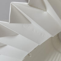 Flemming Agger（フレミング・アガー）がデザインし、Le Klint（レ・クリント）社より発表されたモデル368のフロアランプです。高さ145cmのスマートなフォルムに、ブラックスチールのアームと美しいプリーツシェードが組み合わされ、北欧モダンらしい端正な佇まいを見せます。プラスチックシート製のシェードは光を柔らかく透過し、リビングやベッドサイドに心地よい明かりをもたらします。シンプルながらも計算された構造は職人技が感じられ、ビンテージならではの希少性と存在感を併せ持つ逸品です。