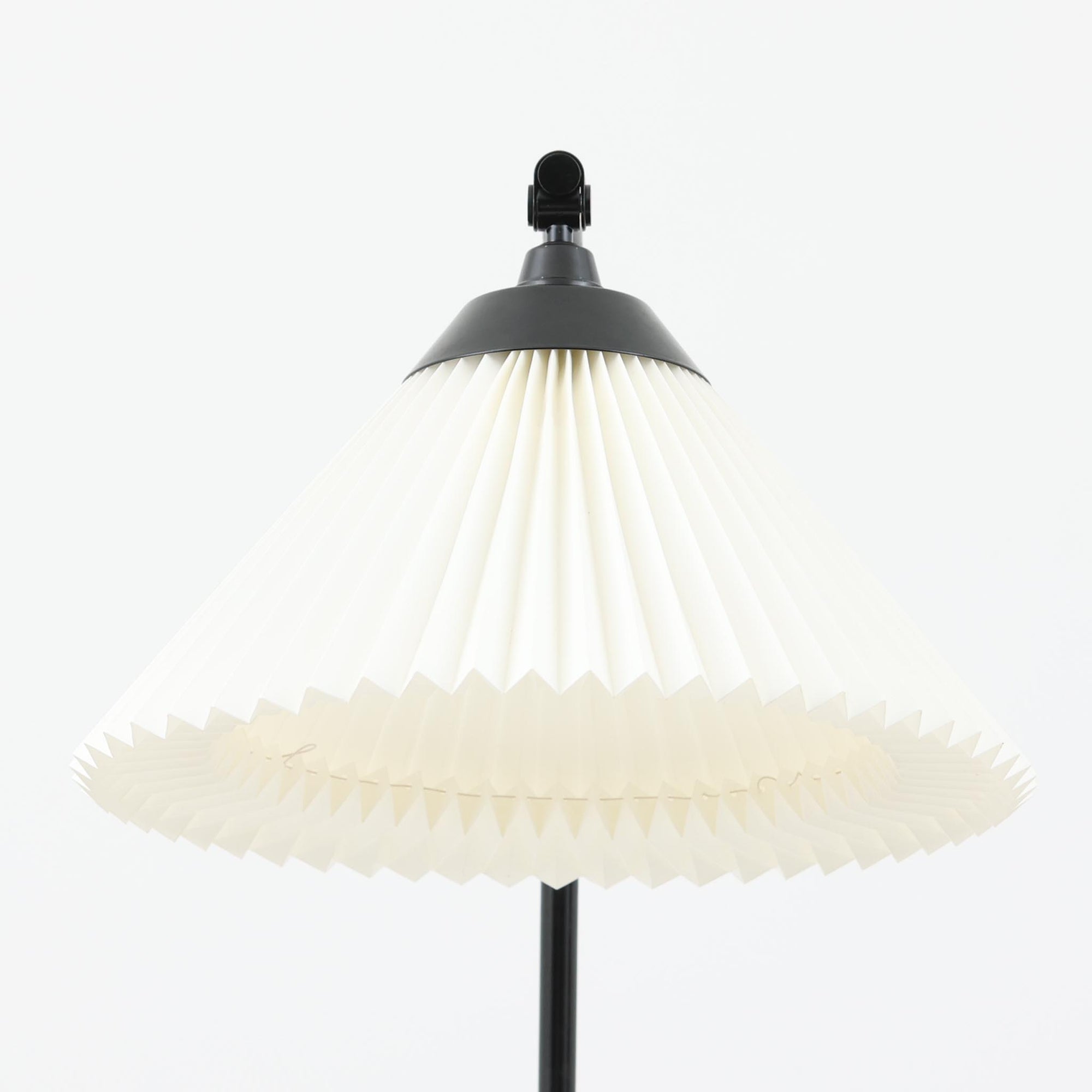 Flemming Agger（フレミング・アガー）がデザインし、Le Klint（レ・クリント）社より発表されたモデル368のフロアランプです。高さ145cmのスマートなフォルムに、ブラックスチールのアームと美しいプリーツシェードが組み合わされ、北欧モダンらしい端正な佇まいを見せます。プラスチックシート製のシェードは光を柔らかく透過し、リビングやベッドサイドに心地よい明かりをもたらします。シンプルながらも計算された構造は職人技が感じられ、ビンテージならではの希少性と存在感を併せ持つ逸品です。