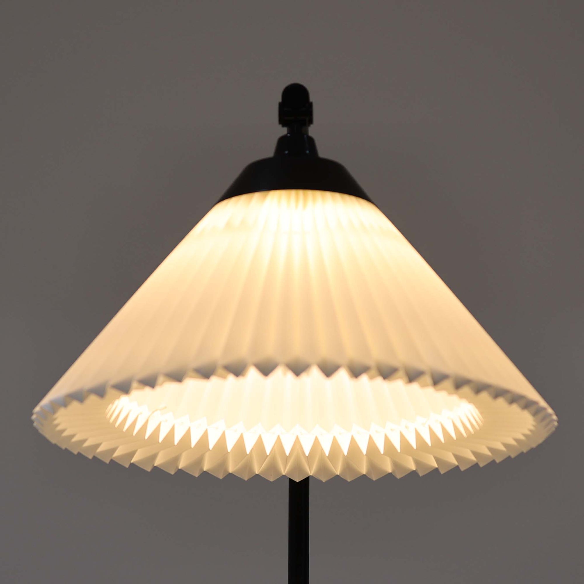 Flemming Agger（フレミング・アガー）がデザインし、Le Klint（レ・クリント）社より発表されたモデル368のフロアランプです。高さ145cmのスマートなフォルムに、ブラックスチールのアームと美しいプリーツシェードが組み合わされ、北欧モダンらしい端正な佇まいを見せます。プラスチックシート製のシェードは光を柔らかく透過し、リビングやベッドサイドに心地よい明かりをもたらします。シンプルながらも計算された構造は職人技が感じられ、ビンテージならではの希少性と存在感を併せ持つ逸品です。