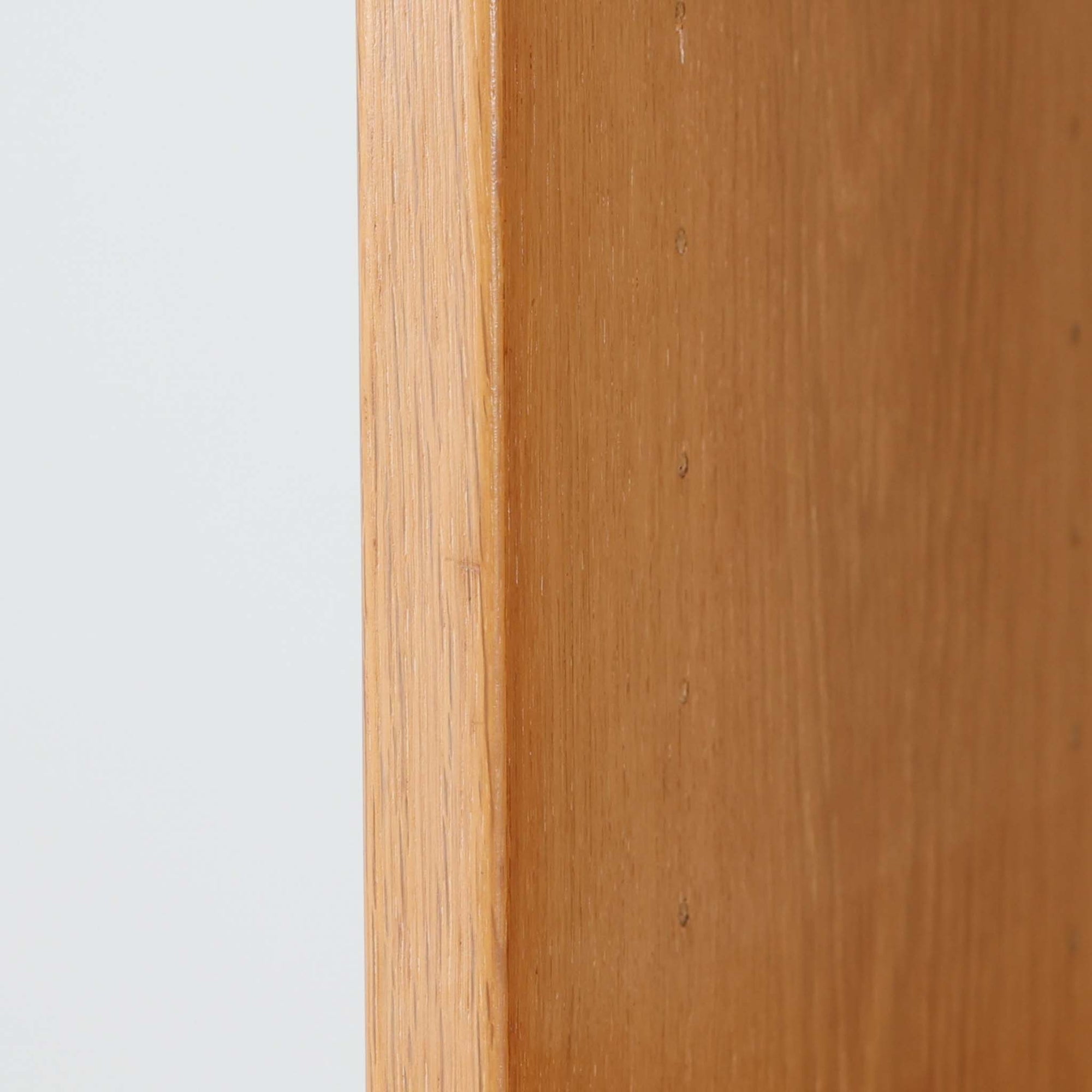 Borge Mogensenがデザインし、Karl Andersson &amp; Sonerが製作した幅135cmのブックシェルフです。上質なオーク材を用いた無駄のない直線的な構成が特徴で、中央の仕切りにより整然とした収納を実現しています。固定棚による堅牢な構造は、日常使いの書籍や資料をしっかりと支え、空間に落ち着いた存在感をもたらします。素材の質感を活かした端正な佇まいは、リビングや書斎、オフィスにも自然に馴染み、北欧ビンテージならではの実直な美しさと経年変化の魅力を感じられる一品です。