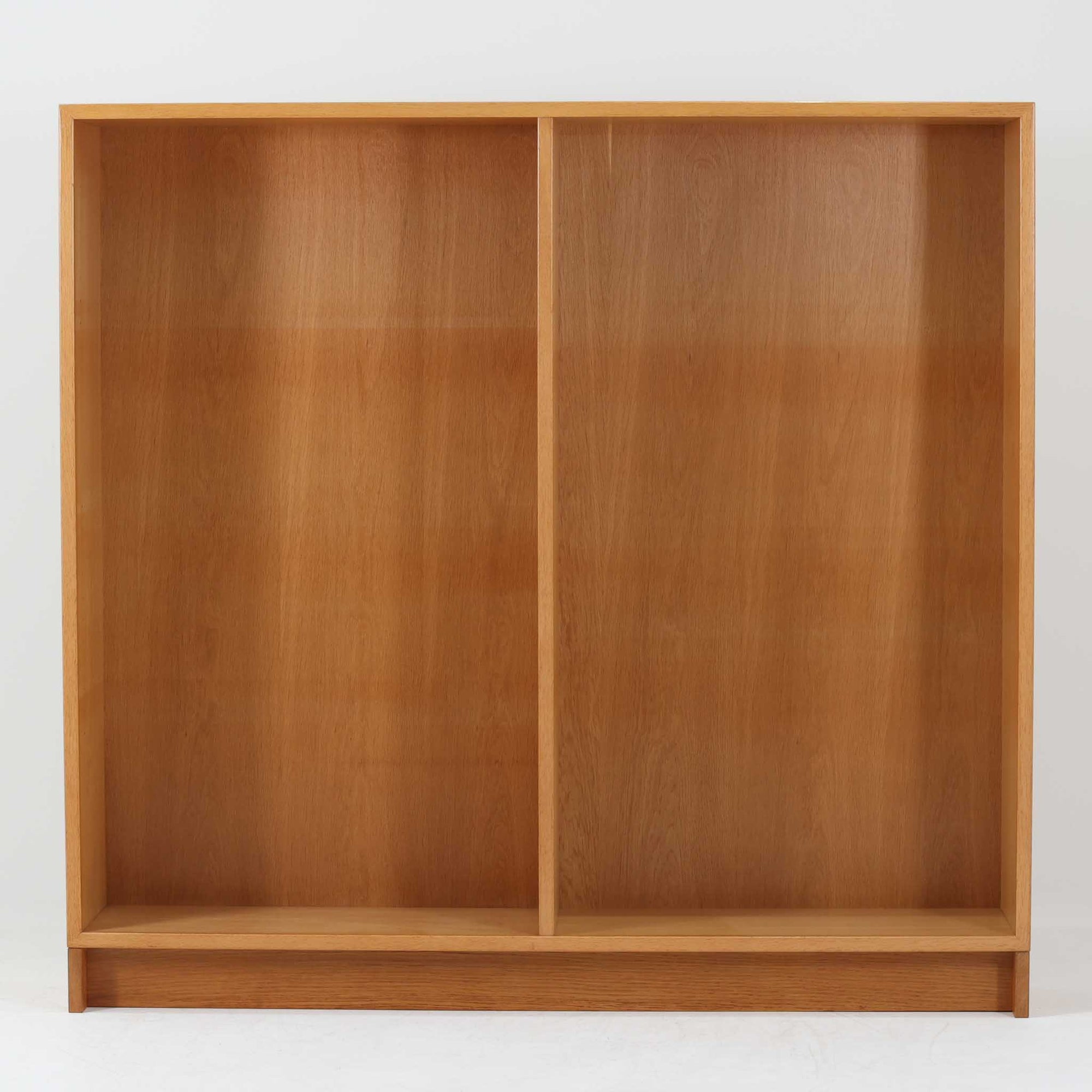 Borge Mogensenがデザインし、Karl Andersson &amp; Sonerが製作した幅135cmのブックシェルフです。上質なオーク材を用いた無駄のない直線的な構成が特徴で、中央の仕切りにより整然とした収納を実現しています。固定棚による堅牢な構造は、日常使いの書籍や資料をしっかりと支え、空間に落ち着いた存在感をもたらします。素材の質感を活かした端正な佇まいは、リビングや書斎、オフィスにも自然に馴染み、北欧ビンテージならではの実直な美しさと経年変化の魅力を感じられる一品です。