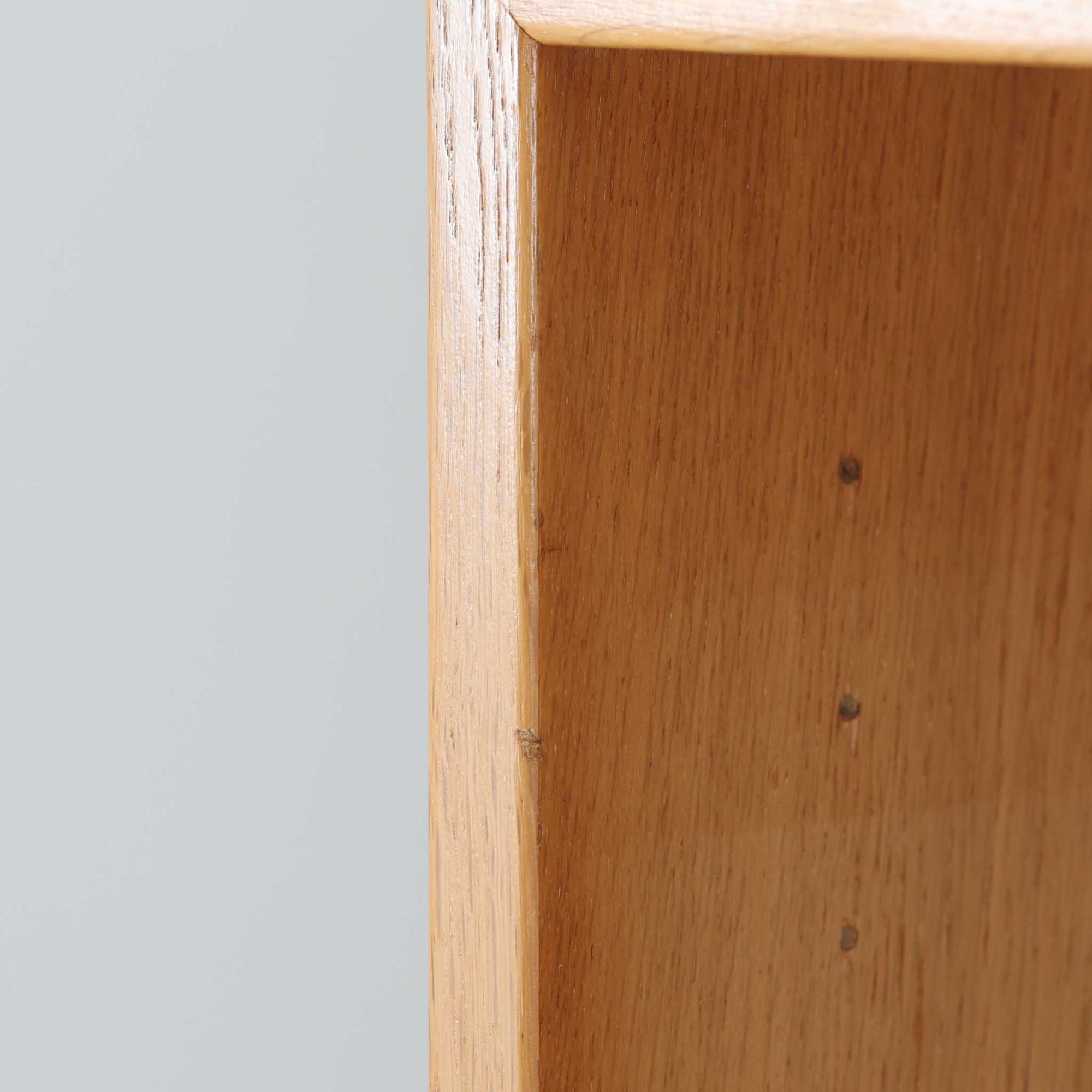 Borge Mogensenがデザインし、Karl Andersson &amp; Sonerが製作した幅135cmのブックシェルフです。上質なオーク材を用いた無駄のない直線的な構成が特徴で、中央の仕切りにより整然とした収納を実現しています。固定棚による堅牢な構造は、日常使いの書籍や資料をしっかりと支え、空間に落ち着いた存在感をもたらします。素材の質感を活かした端正な佇まいは、リビングや書斎、オフィスにも自然に馴染み、北欧ビンテージならではの実直な美しさと経年変化の魅力を感じられる一品です。