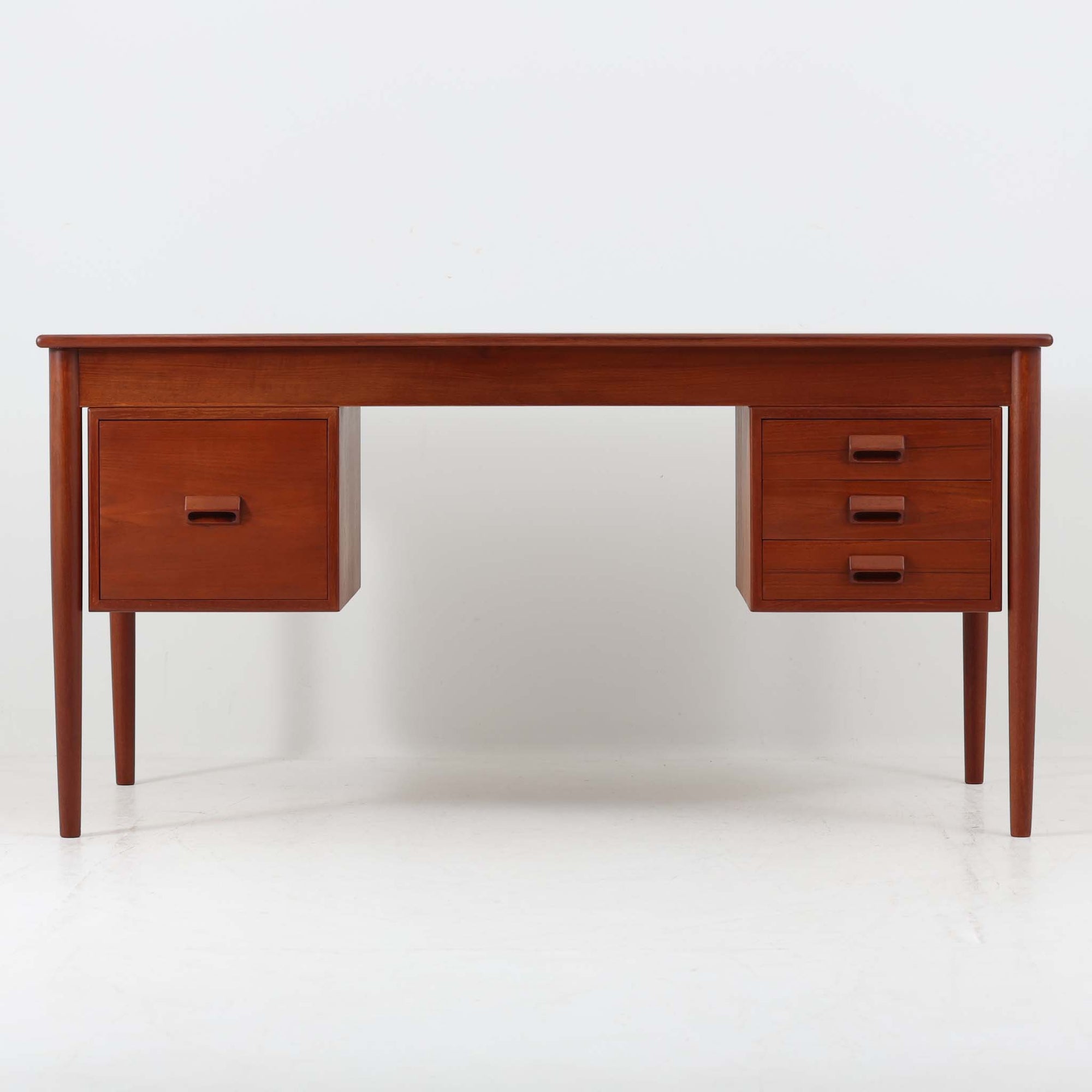 Borge MogensenがSoborg Mobler社のためにデザインしたModel 130の両袖デスクです。良質なチーク材を全面に使用した仕様は珍しく、温かみと重厚感を兼ね備えています。右側には3杯の引き出し、左側には1杯の深型引き出しを備えた構成もスタンダードな3段＋2段タイプとは異なる希少なディテールです。幅146cmと程よいサイズ感で、書斎やオフィスに取り入れやすく、実用性と存在感を兼ね備えています。直線的で力強いフォルムはモーエンセンらしい機能美を体現し、経年により深みを増したチーク材の風合いが空間に格調を添えるビンテージデスクです。
