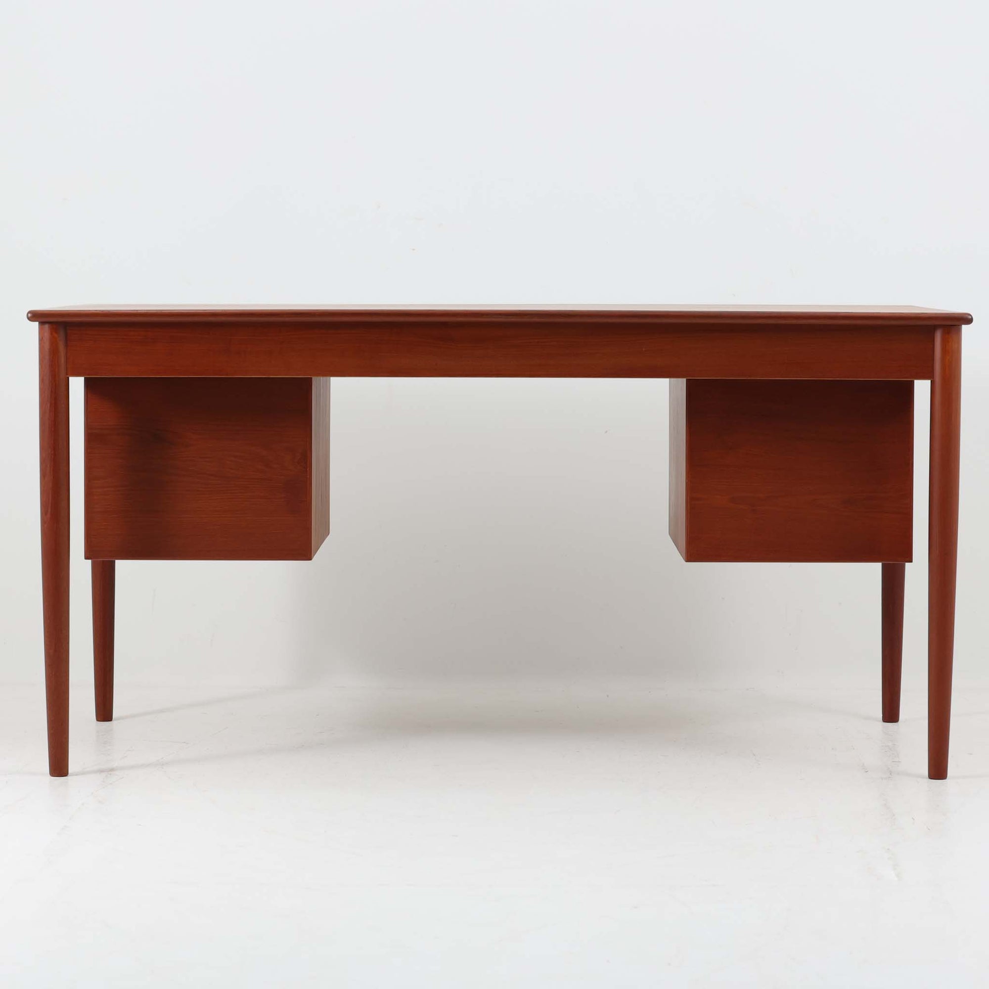 Borge MogensenがSoborg Mobler社のためにデザインしたModel 130の両袖デスクです。良質なチーク材を全面に使用した仕様は珍しく、温かみと重厚感を兼ね備えています。右側には3杯の引き出し、左側には1杯の深型引き出しを備えた構成もスタンダードな3段＋2段タイプとは異なる希少なディテールです。幅146cmと程よいサイズ感で、書斎やオフィスに取り入れやすく、実用性と存在感を兼ね備えています。直線的で力強いフォルムはモーエンセンらしい機能美を体現し、経年により深みを増したチーク材の風合いが空間に格調を添えるビンテージデスクです。