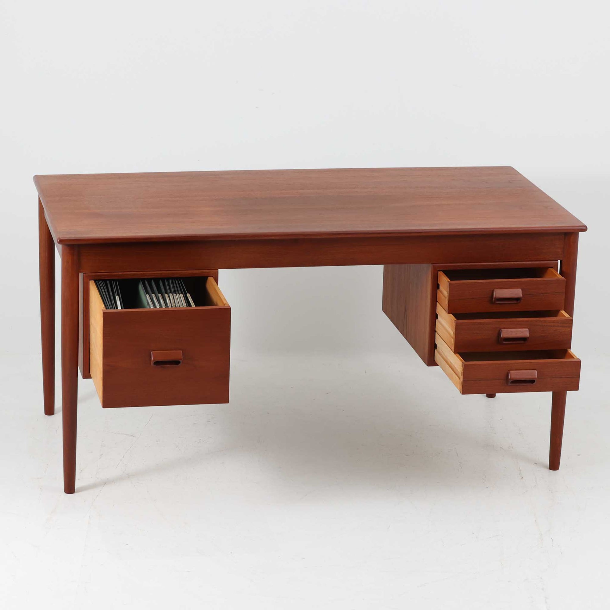 Borge MogensenがSoborg Mobler社のためにデザインしたModel 130の両袖デスクです。良質なチーク材を全面に使用した仕様は珍しく、温かみと重厚感を兼ね備えています。右側には3杯の引き出し、左側には1杯の深型引き出しを備えた構成もスタンダードな3段＋2段タイプとは異なる希少なディテールです。幅146cmと程よいサイズ感で、書斎やオフィスに取り入れやすく、実用性と存在感を兼ね備えています。直線的で力強いフォルムはモーエンセンらしい機能美を体現し、経年により深みを増したチーク材の風合いが空間に格調を添えるビンテージデスクです。