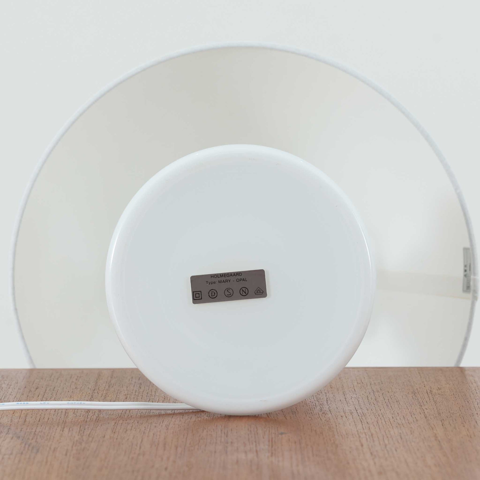 Per Lutken（ペア・ルッケン）によるデザイン、Holmegaard（ホルムガード）製のテーブルランプ「Mary」です。高さ44cmの存在感あるサイズで、滑らかな曲線を描くホワイトガラスのベースは柔らかい光沢を放ち、北欧らしい洗練された印象を与えます。シンプルなリネンシェードを通した光は温かみのある雰囲気を演出し、リビングやベッドサイドに心地よい灯りを添えます。北欧モダンデザインの魅力と職人技が息づくビンテージ照明です。