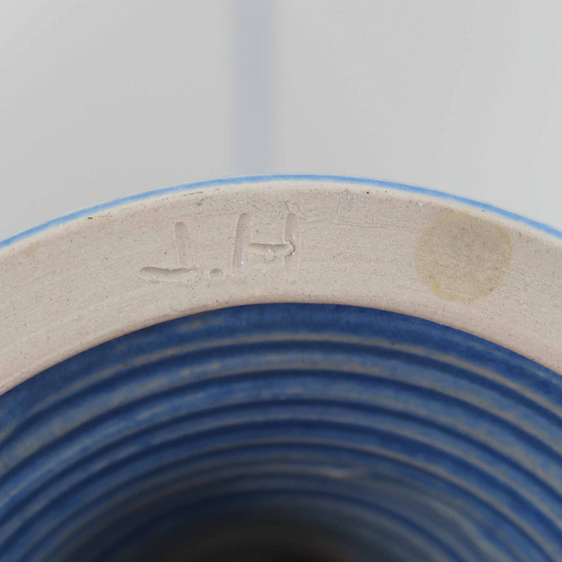 デンマーク製、高さ40cmのテーブルランプです。陶磁器製のベースはブルーとベージュが美しく溶け合うグラデーションが特徴で、ハンドクラフトならではの味わい深い質感が魅力です。裏面には「J.H」の刻印があり、デザインや色使いからデンマークの陶芸家 Jette Hellerøe（イェッテ・ヘレロー）の作品である可能性が高いものの、確証はございません。シンプルなリネンシェードを通した柔らかな光が落ち着いた雰囲気を演出し、リビングやベッドサイドに温もりを添えます。北欧らしいナチュラルな美しさを感じさせるビンテージ照明で、インテリアのアクセントとしてもおすすめの一品です。